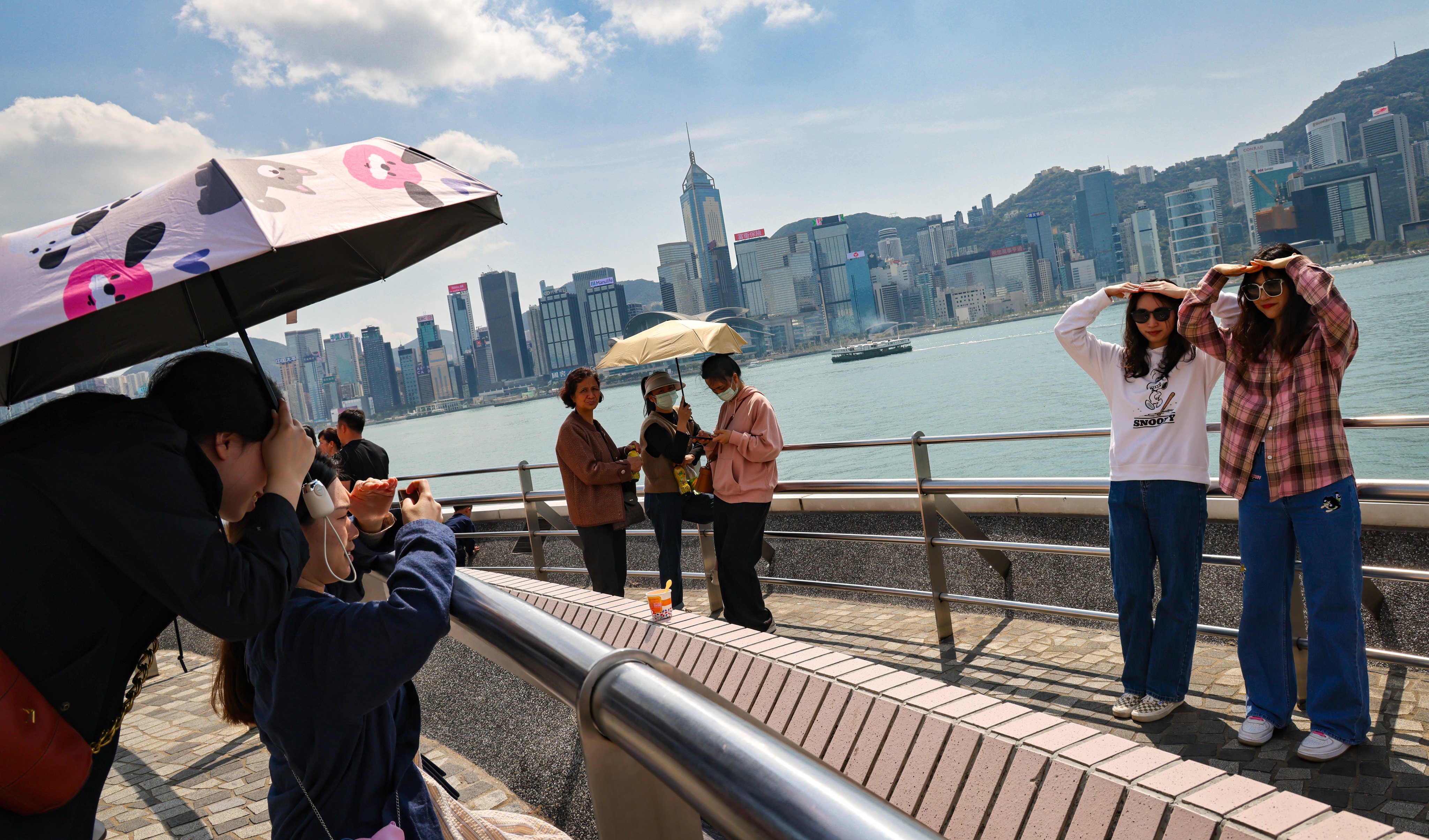 People pose for photos in Tsim Sha Tsui as the weather gradually becomes warmer. Photo: Jelly Tse