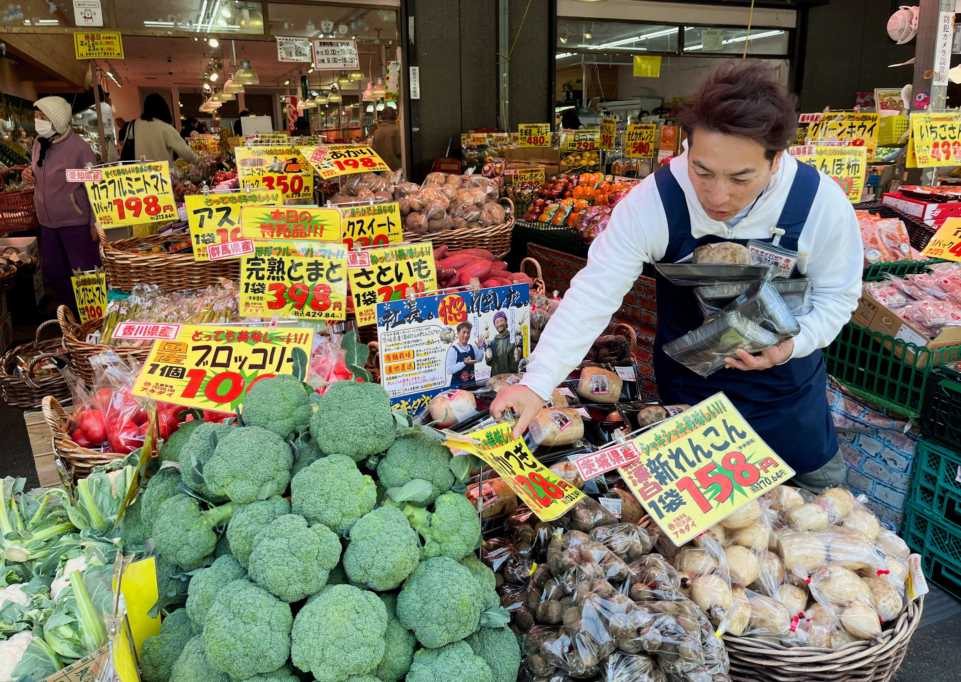 Store owner Hiromichi Akiba works at his supermarket in Tokyo on February 16. While swelling corporate coffers are enriching global investors. Japanese workers face stagnant wages. Photo: Reuters