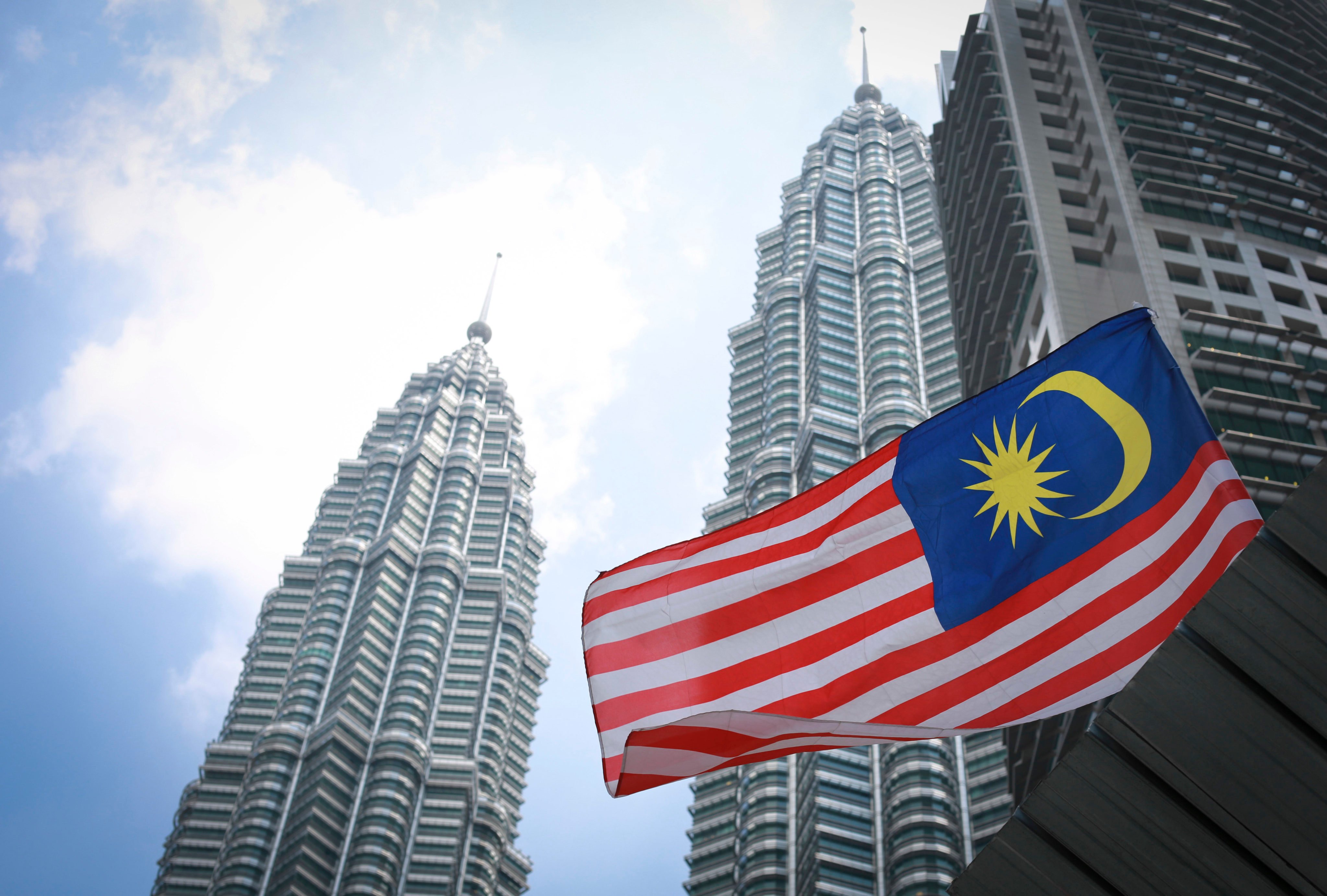 Malaysia’s national flag flies in front of its landmark Petronas Twin Towers in Kuala Lumpur. The nation’s central bank said Malaysia’s economic growth this year will be driven by improved external demand and strong domestic spending. Photo: AP
