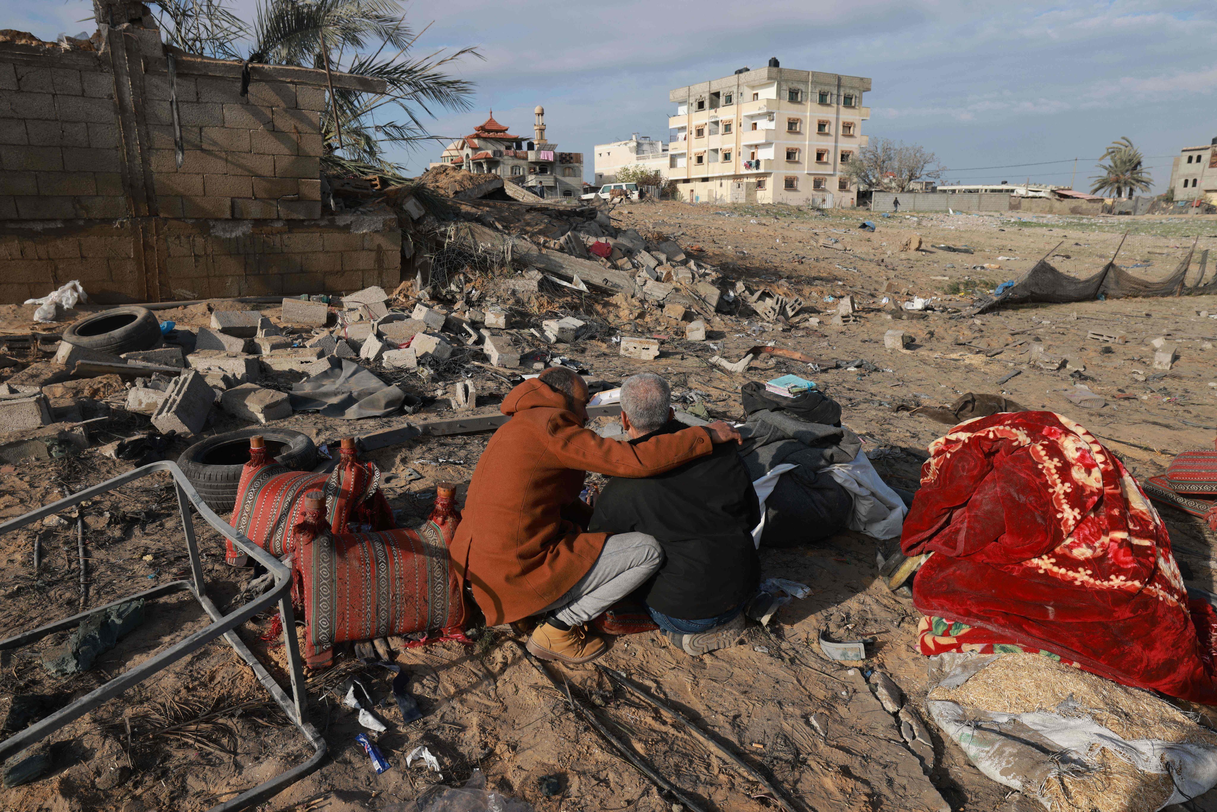 A Palestinian man comforts another as they inspect the destruction in Rafah on Monday following overnight Israeli air strikes on the southern Gaza border city. Photo: AFP
