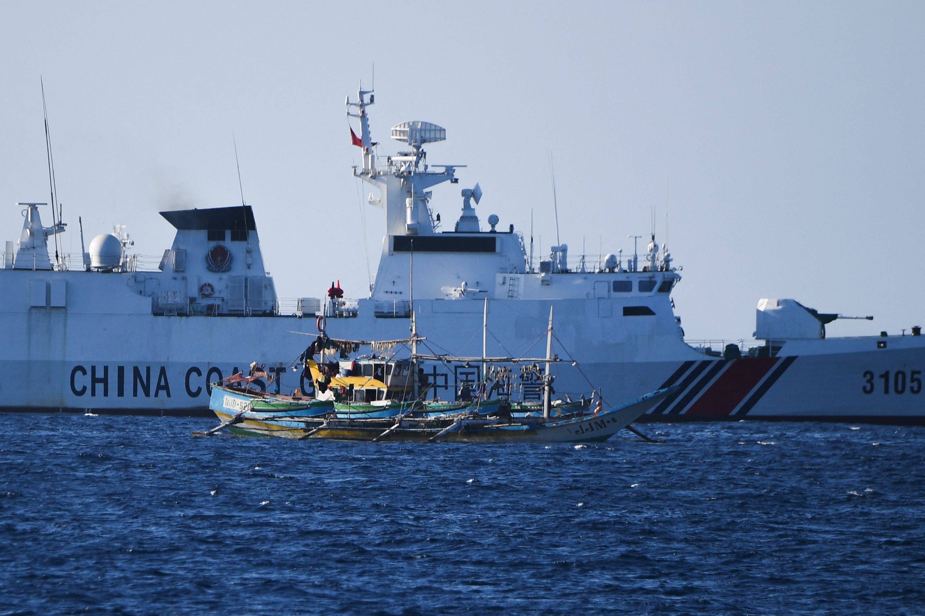 A Chinese coast guard ship sailing past a Philippine fishing boat on February 15 near the China-controlled Scarborough Shoal in the disputed South China Sea. Photo: AFP