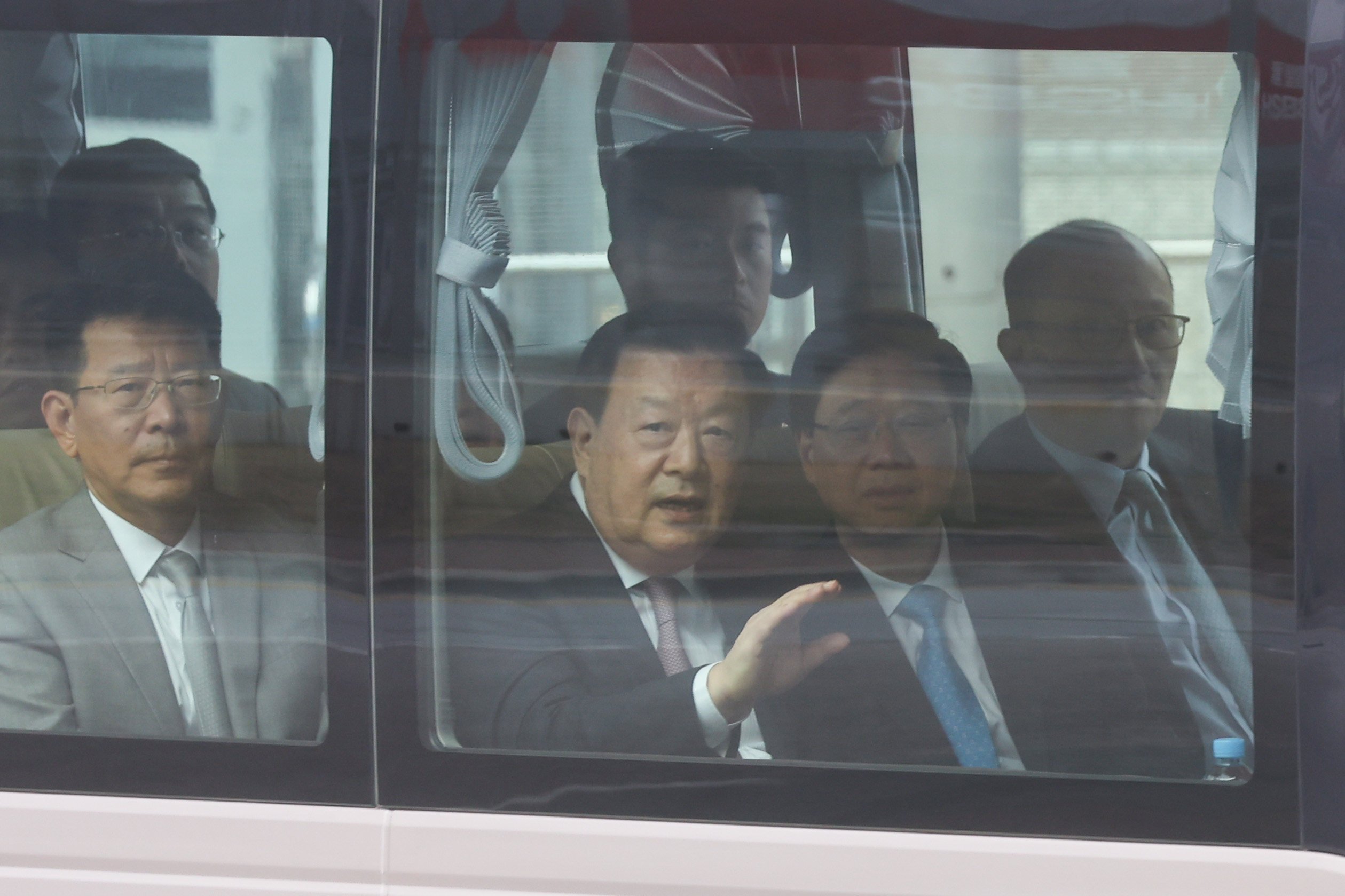 Xia Baolong (centre), director of the Hong Kong and Macau Affairs Office, waves from a bus alongside city leader John Lee (second from right). Photo: Edmond So