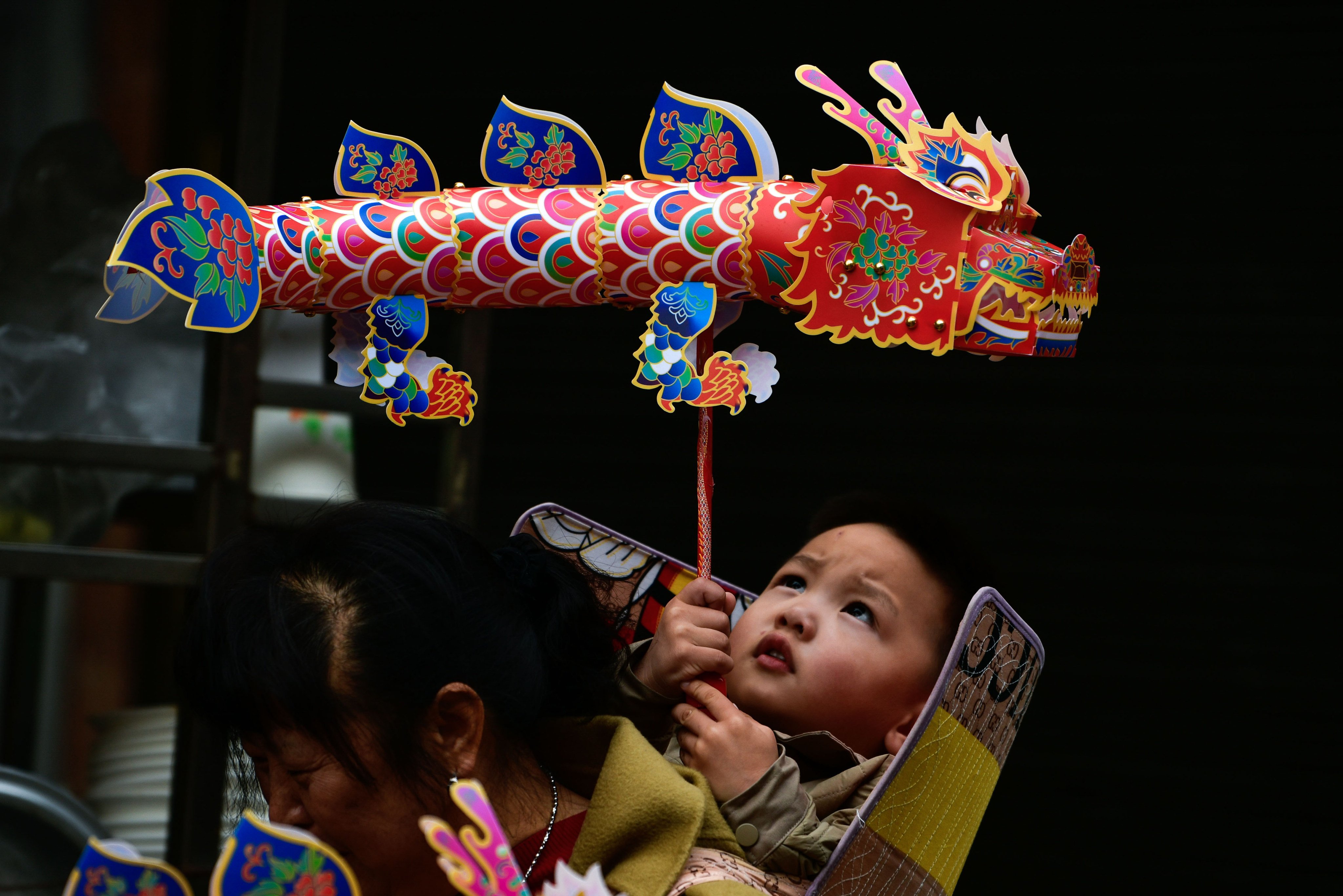 A child holds up a toy dragon in Shiqian county in China’s southwestern province of Guizhou on February 20. Chinese culture can be seen as influencing the English lexicon by adding new meanings to the word “dragon”. Photo: Xinhua