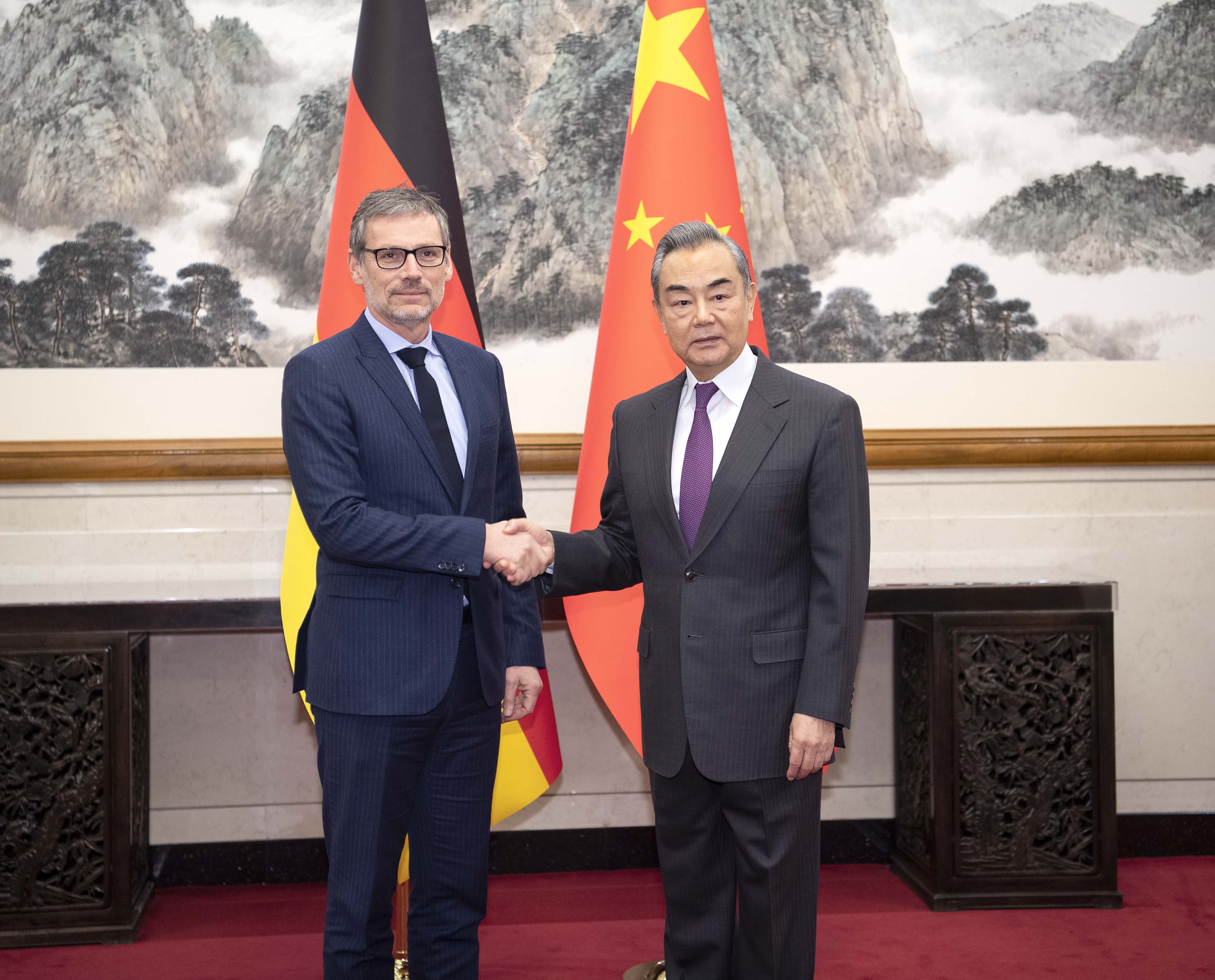 Chinese Foreign Minister Wang Yi (right) shakes hands with German foreign policy adviser Jens Plotner in Beijing on Friday. Photo: Xinhua