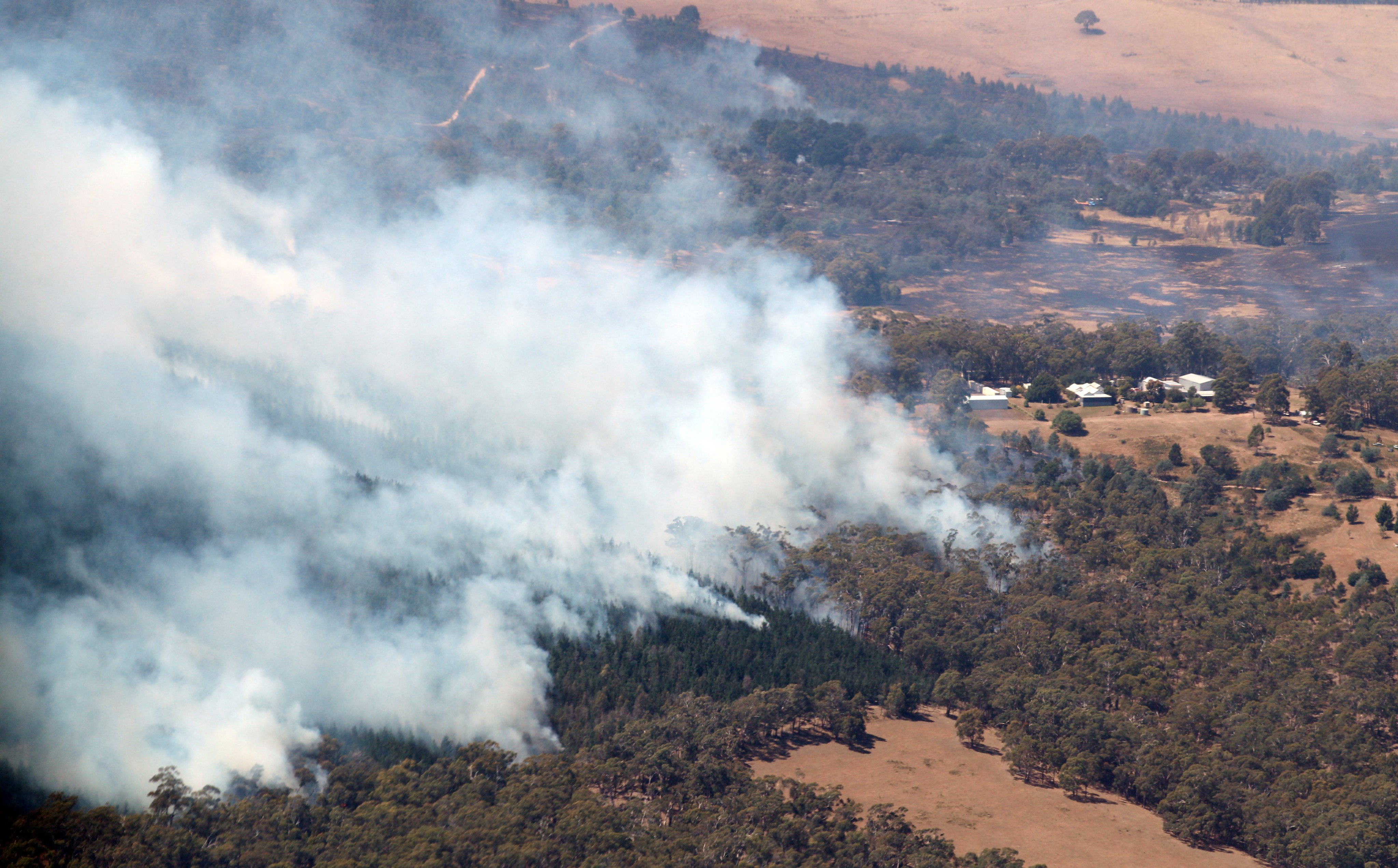 Smoke from bushfires rises north of Beaufort, near Ballarat in Victoria, Australia, on Saturday. Photo: AAP/Pool/via Reuters