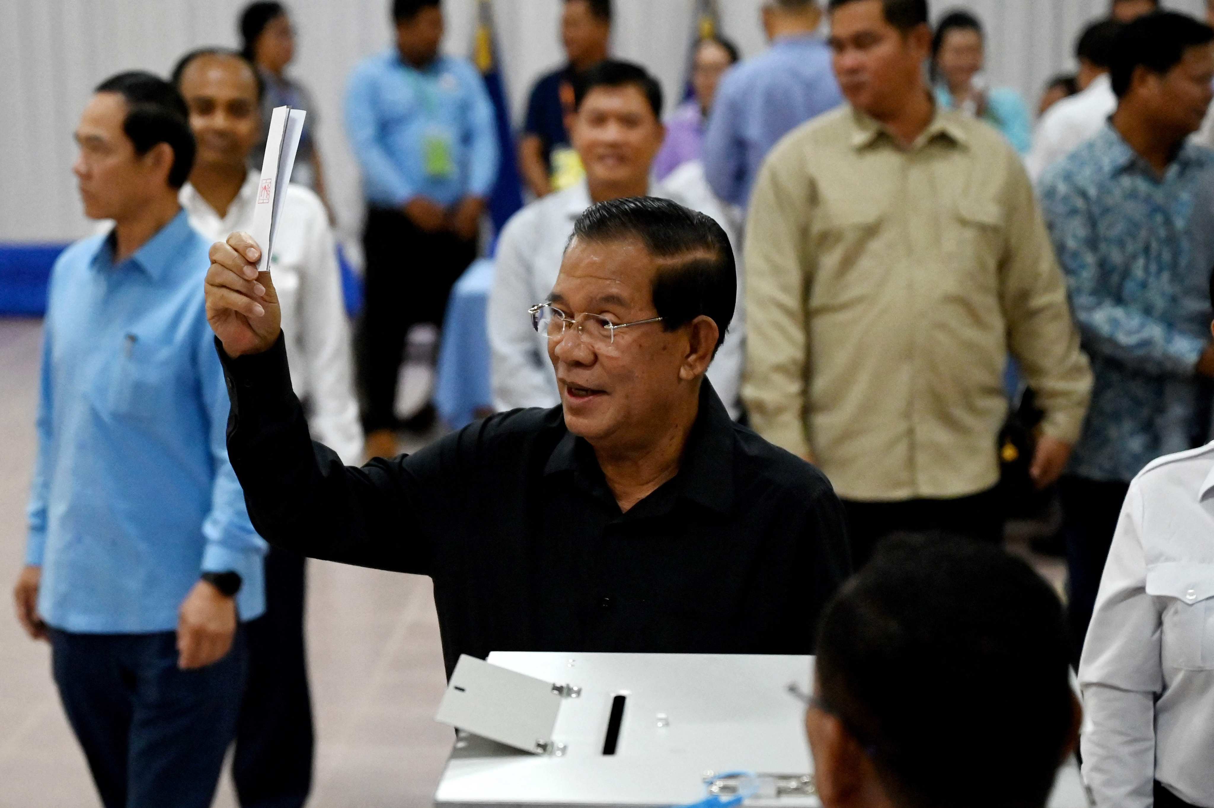 Former Prime Minister Hun Sen shows a ballot paper as he votes at a polling station during the Senate election in Takhmao city, Kandal province, on Sunday. Photo: AFP