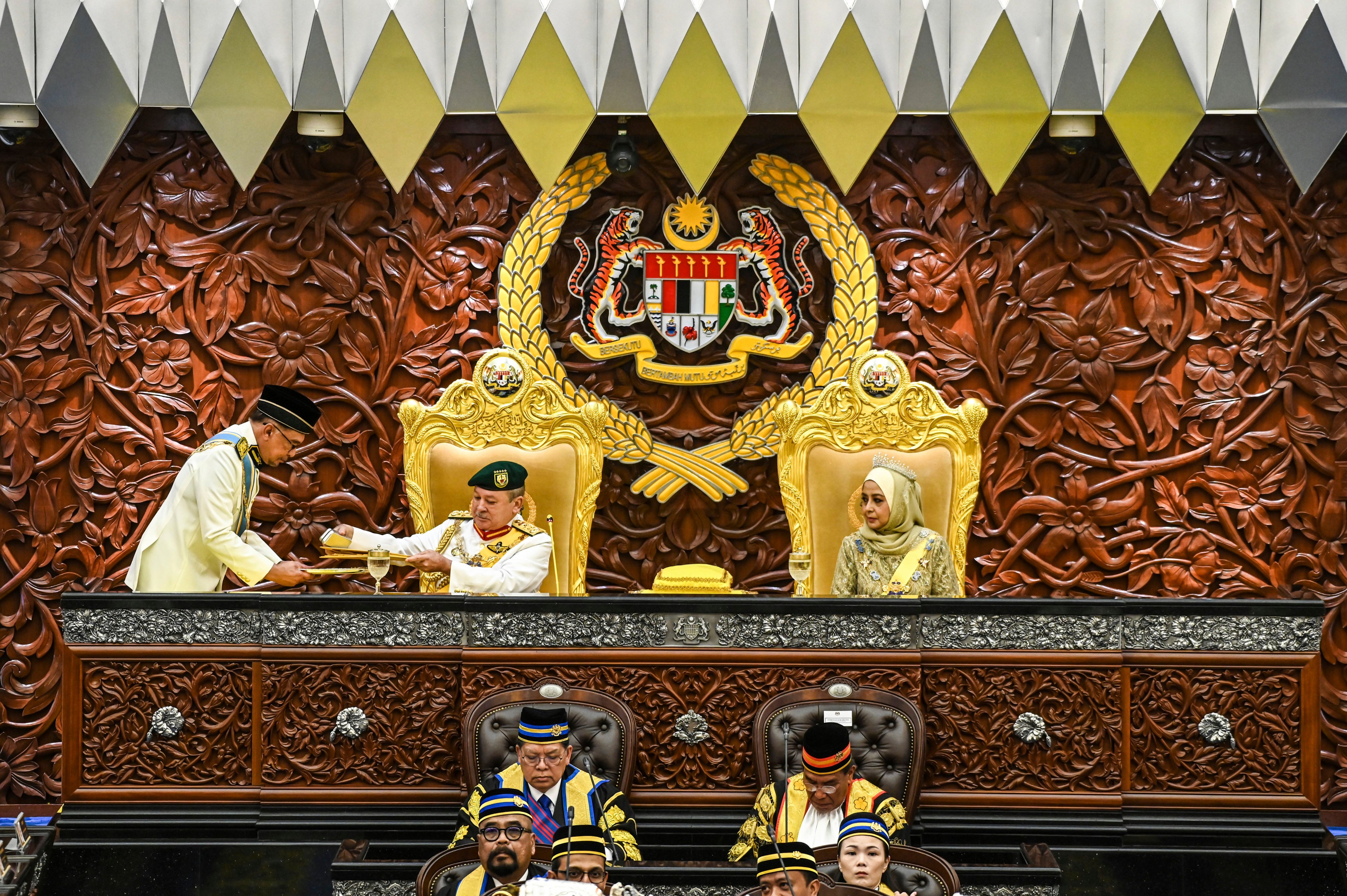 Malaysia’s king Sultan Ibrahim Iskandar receives documents from Prime Minister Anwar Ibrahim as queen Raja Zarith Sofiah looks on during the opening ceremony of the parliamentary session at parliament house in Kuala Lumpur. photo: AP