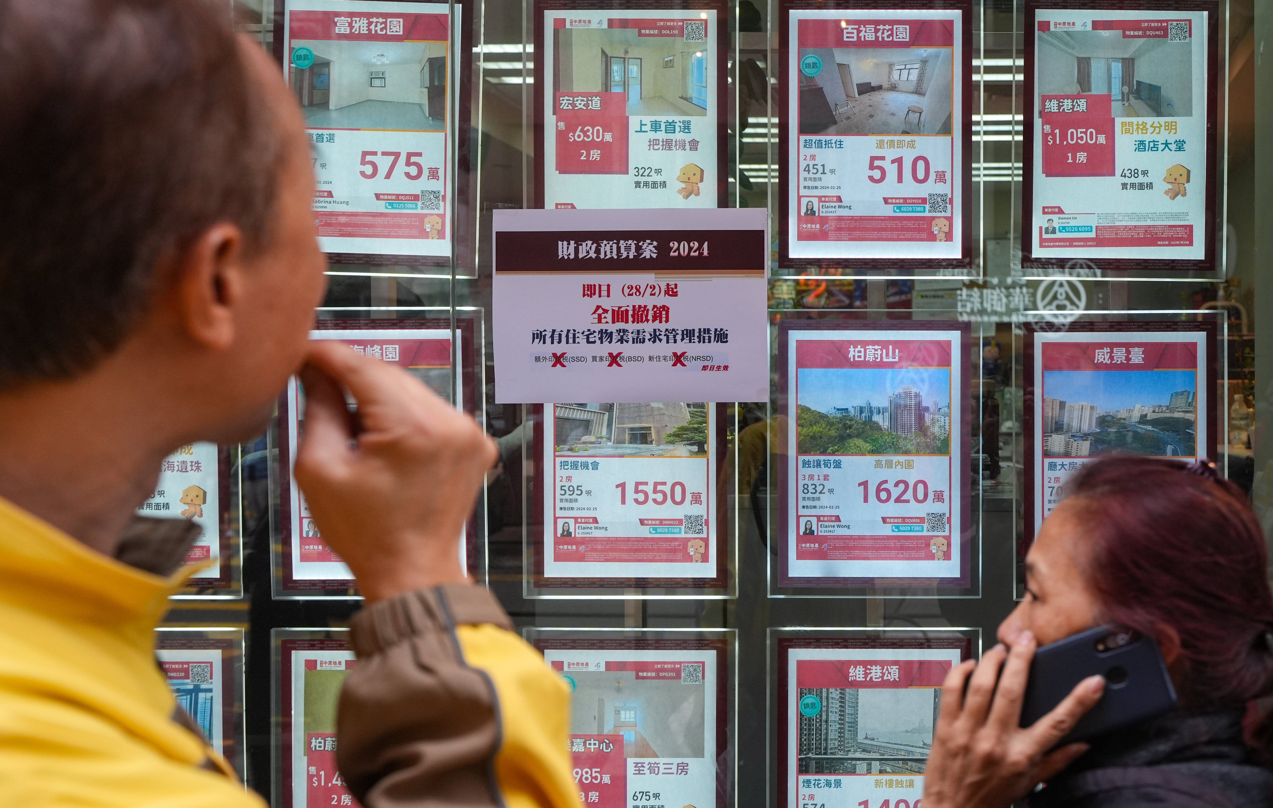 The end of restrictions designed to cool the property market are highlighted in the window of a property agency Photo: Eugene Lee