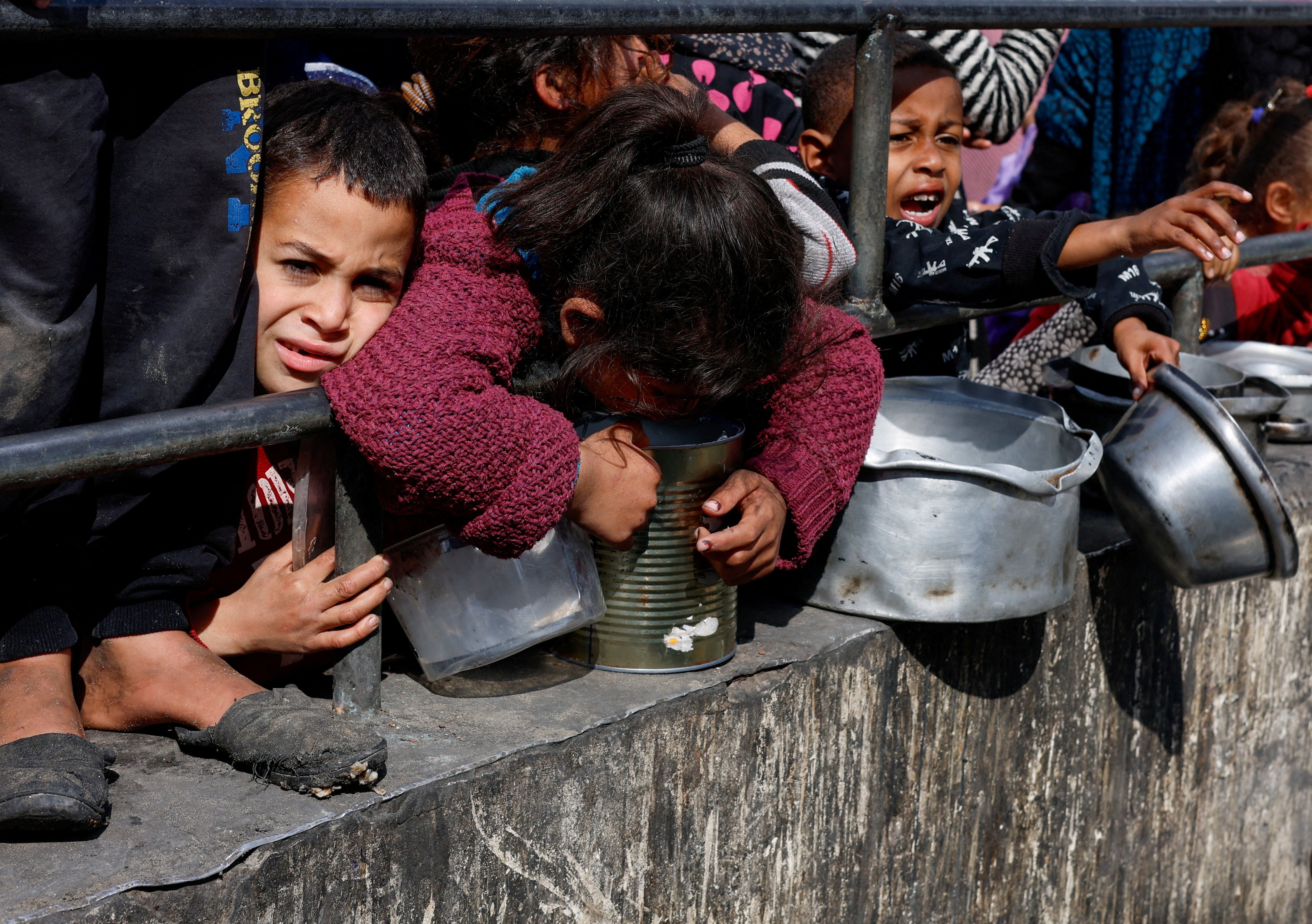 Palestinian children wait to receive food cooked by a charity kitchen on February 20, as the United Nations Security Council fails to pass a resolution calling for a ceasefire. Photo: Reuters