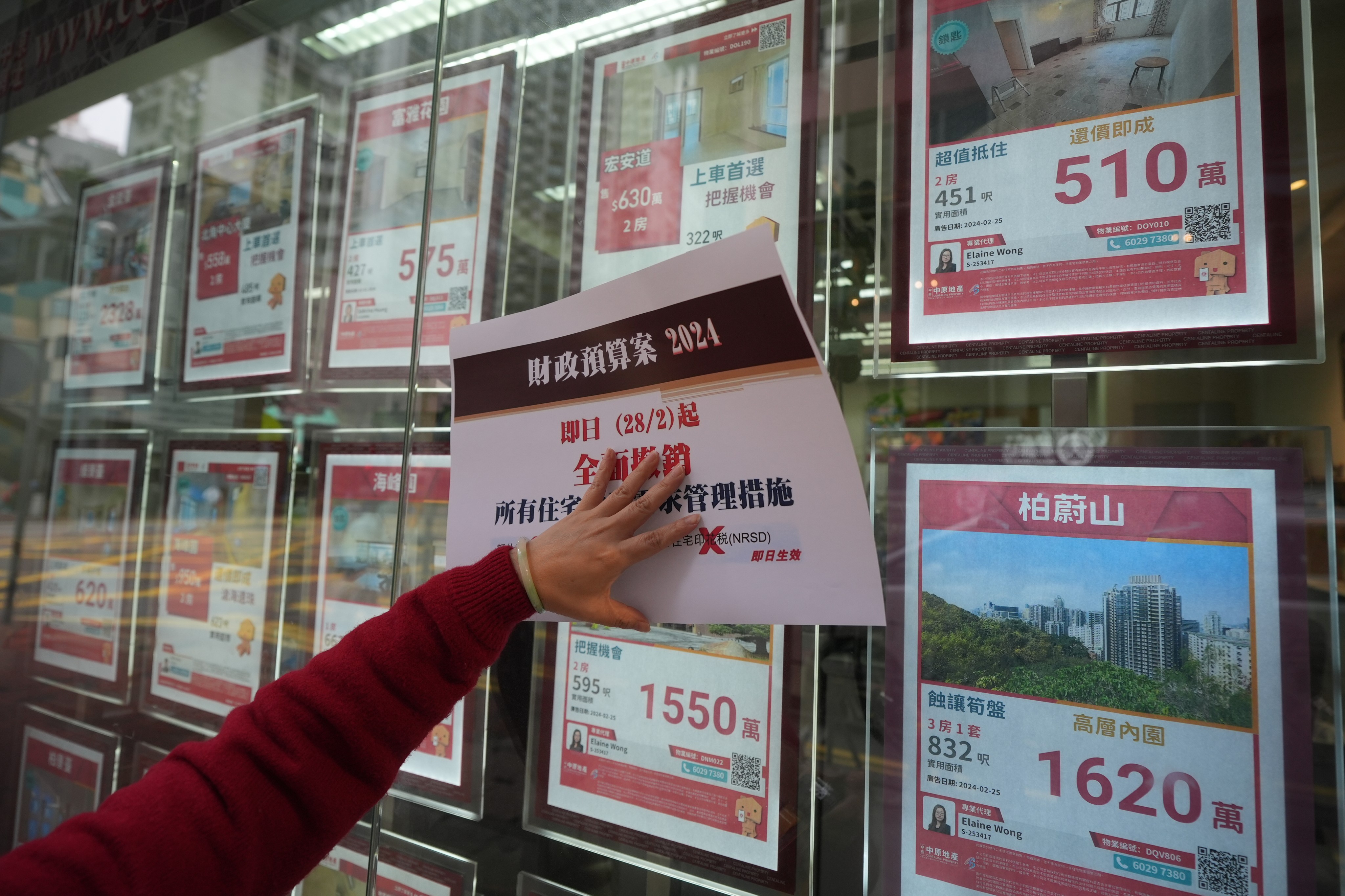 A property branch in Fortress Hill displays a poster stating the removal of property curbs as Financial Secretary Paul Chan delivers this year’s budget address. Photo: Eugene Lee