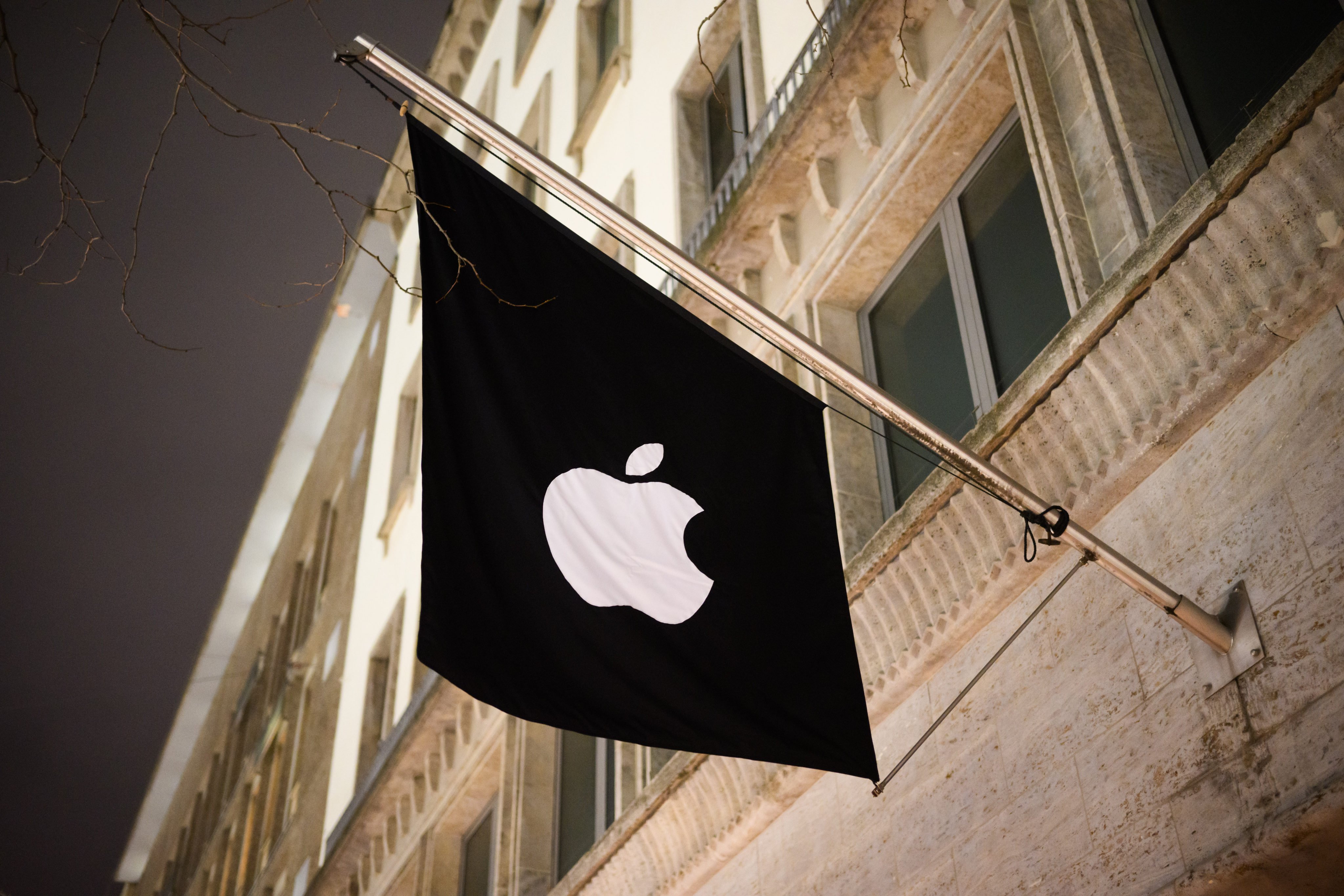 A flag with the Apple logo hangs in front of one of the company's stores in Germany. Photo: Julian Stratenschulte/dpa