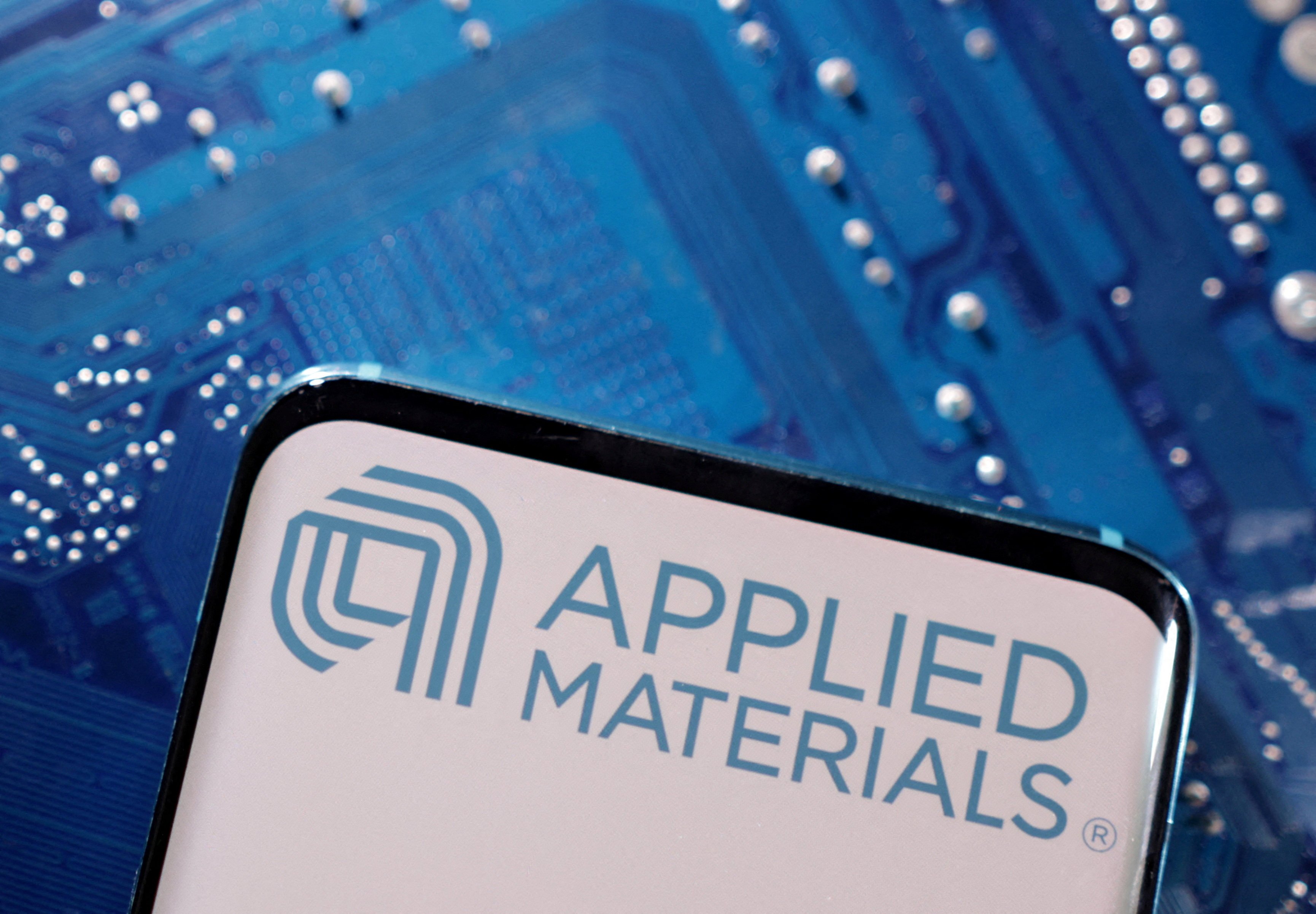 A smartphone with a displayed Applied Materials logo is placed on a computer motherboard in this illustration taken on March 6, 2023. Photo: Reuters