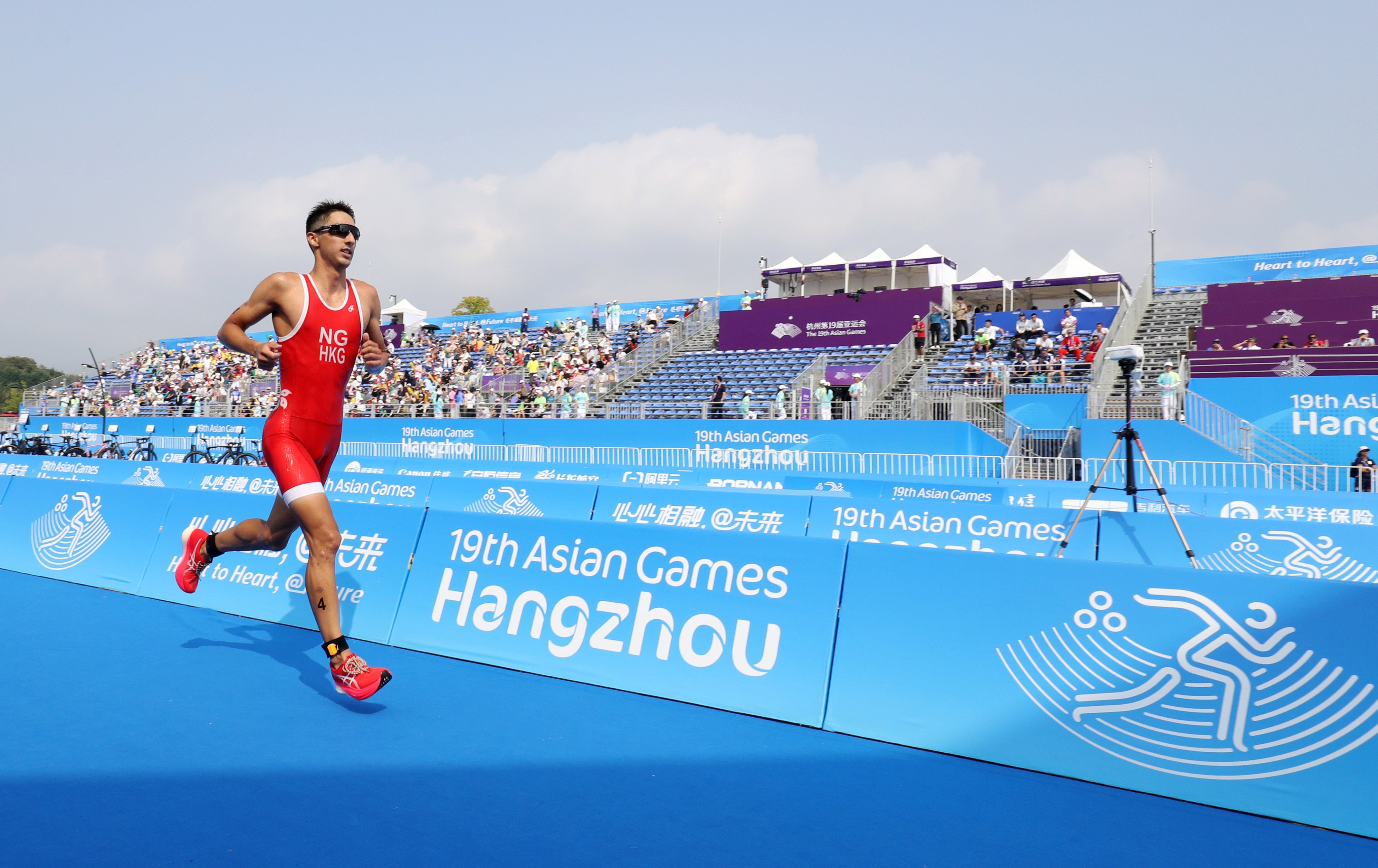 Hong Kong’s Jason Ng runs down the finish chute at the end of the men’s triathlon at the Asian Games in Hangzhou. Photo: SF&OC