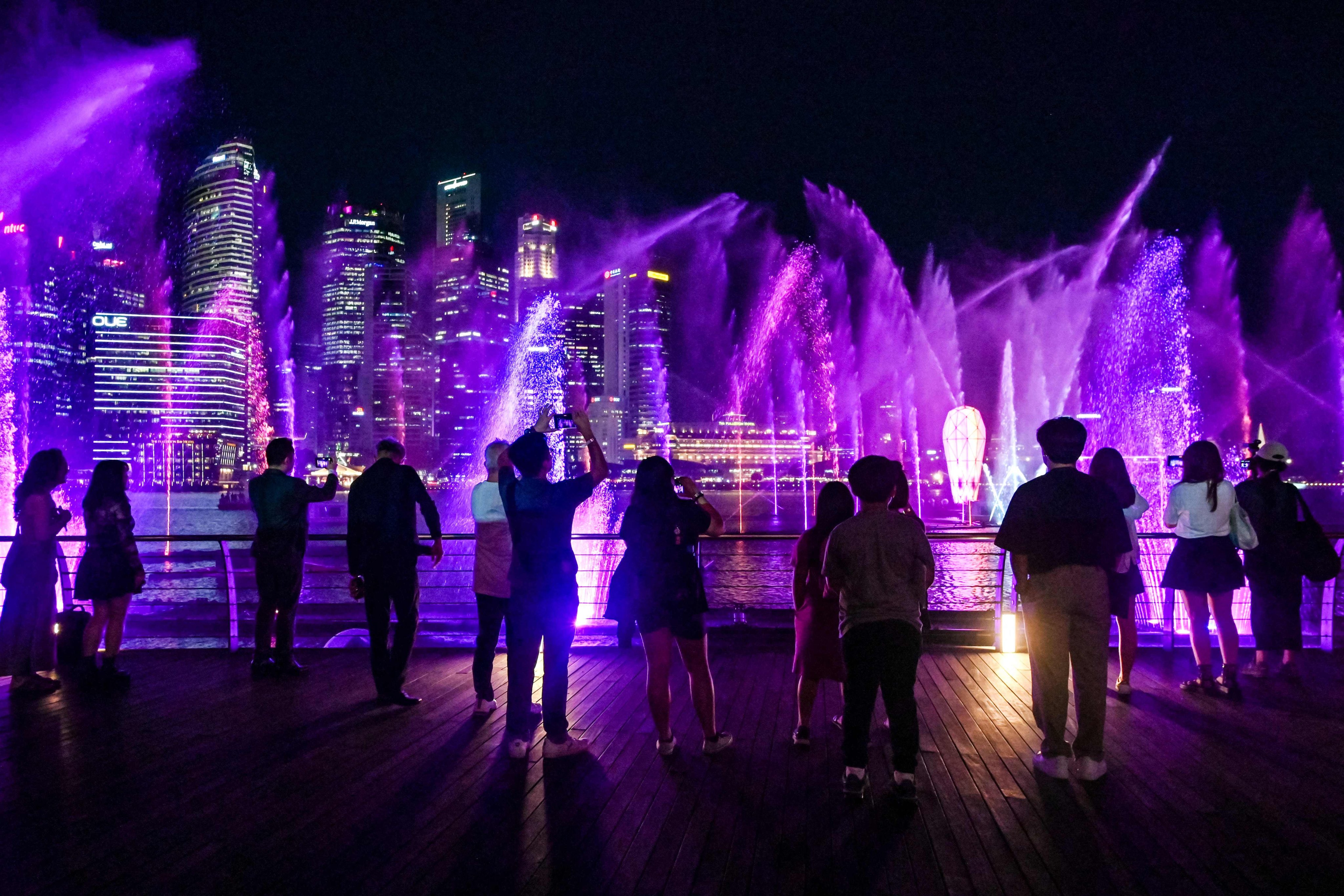 Fans of singer Taylor Swift watch a light and water show in the “Eras Tour Trail” that depicts different eras of the pop star’s career at Marina Bay Sands in Singapore on February 28. Photo: AFP
