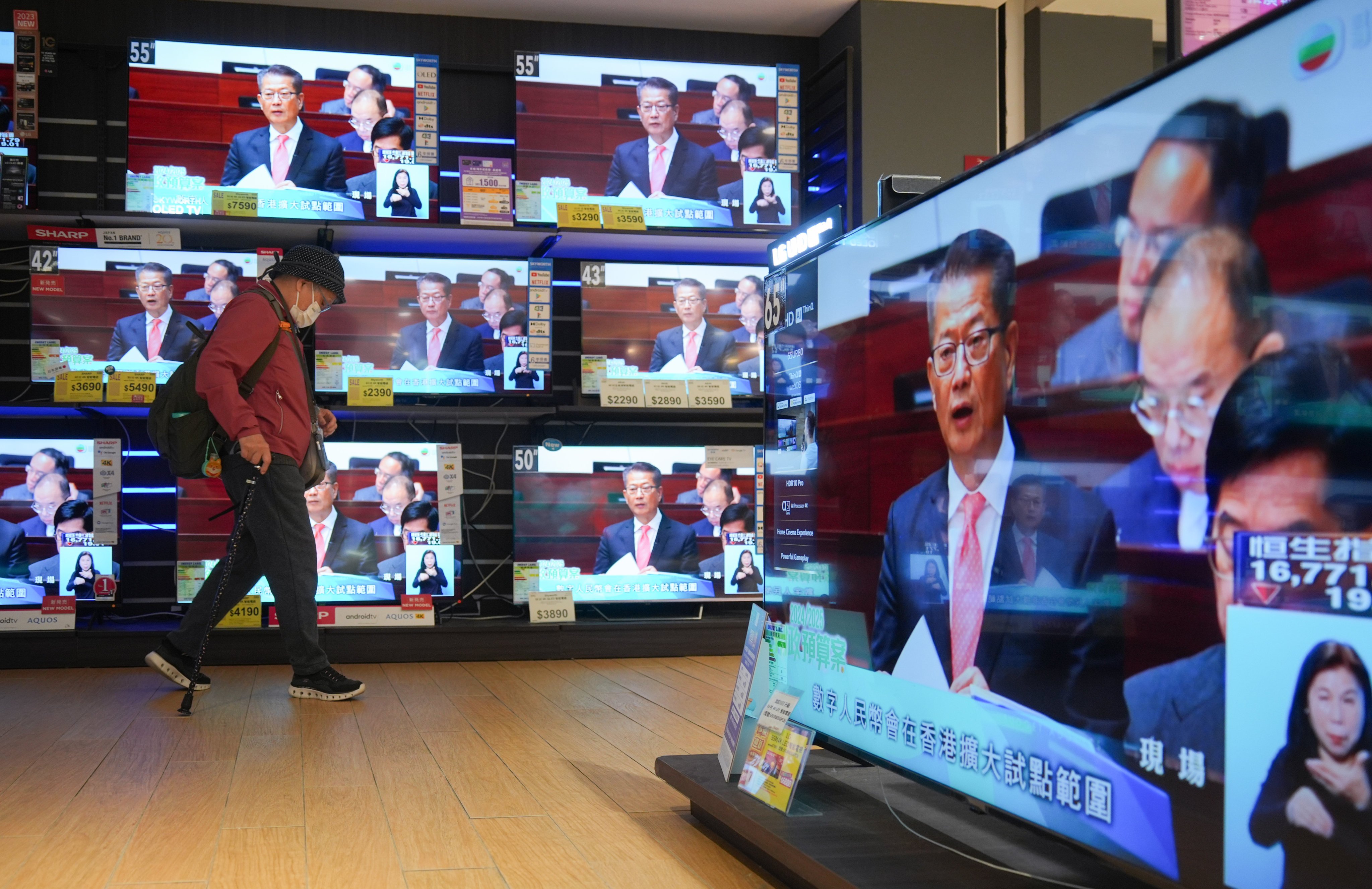 Televisions in an electronics shop show Financial Secretary Paul Chan delivering his budget address on Wednesday. Photo: Eugene Lee