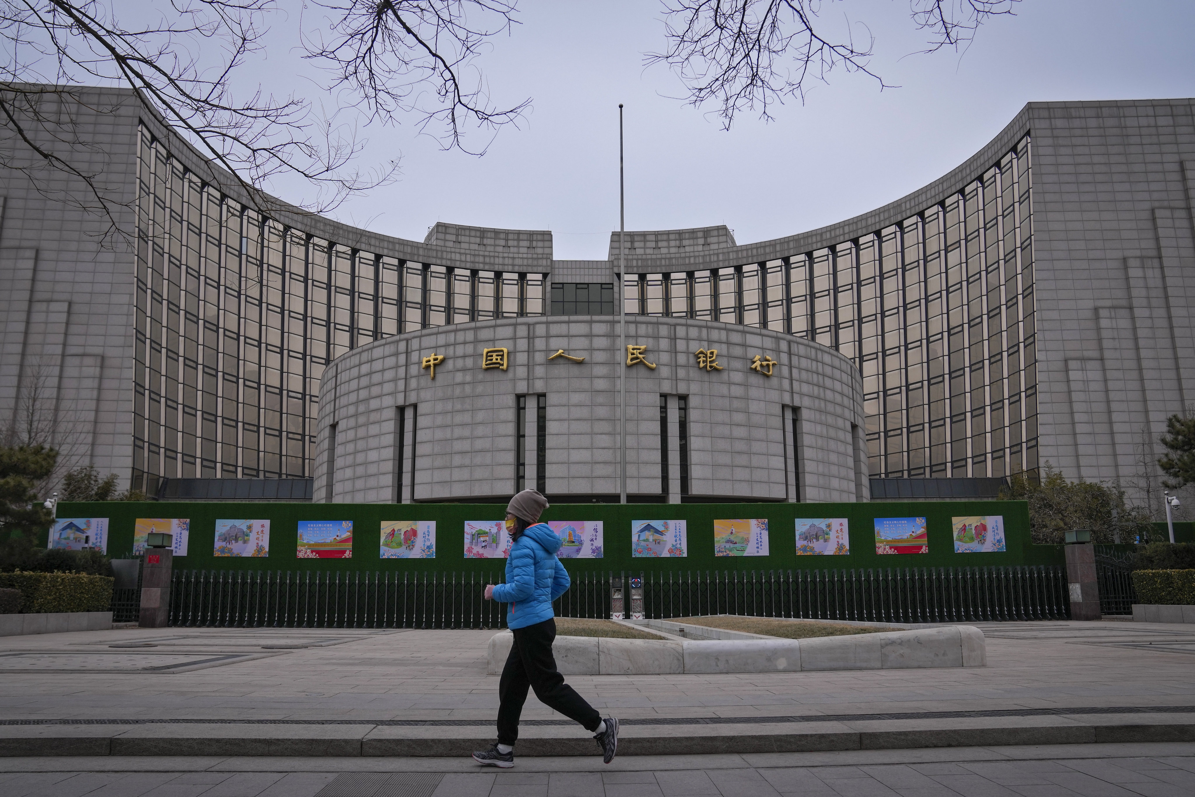 A woman jogs past China’s central bank, or the People’s Bank of China, in Beijing on February 20, 2024. Photo: AP