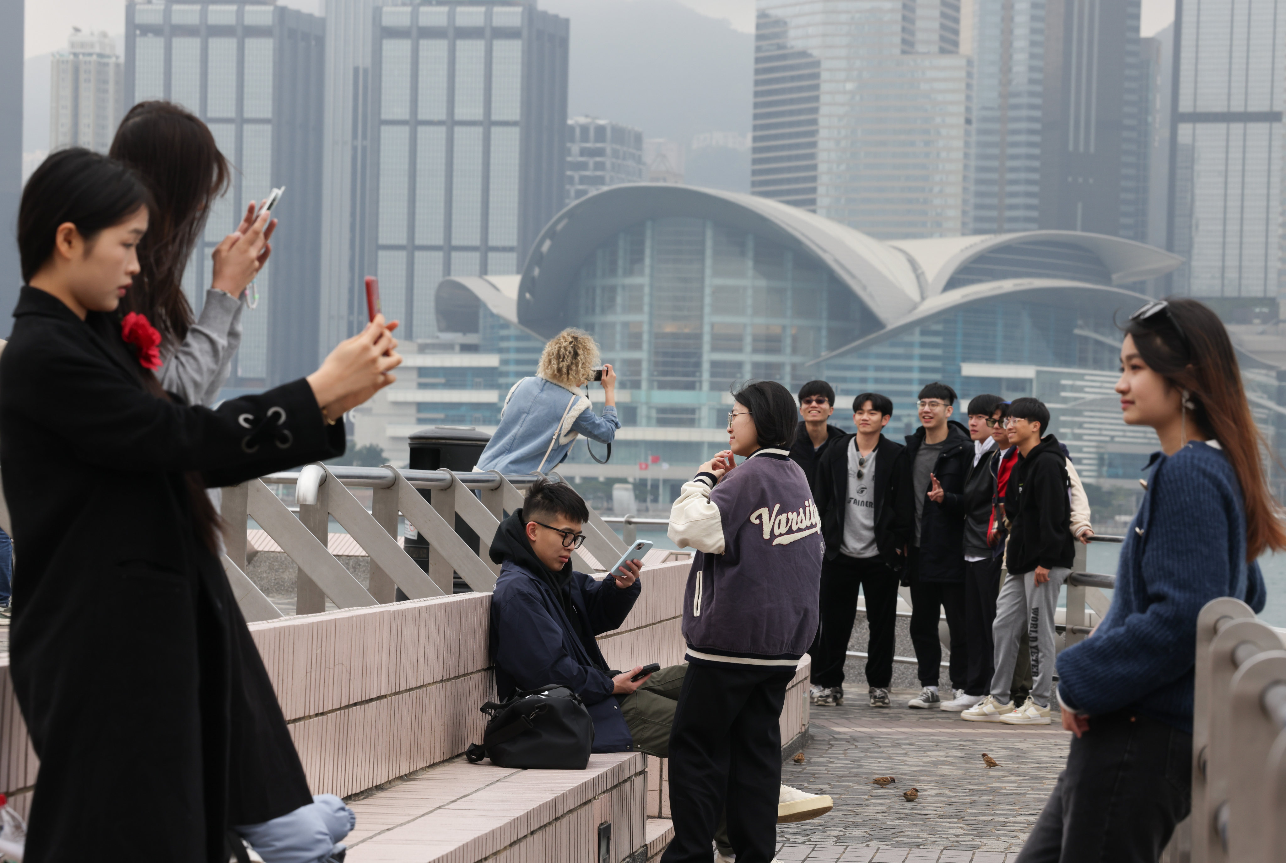 Tourists take photos at the Tsim Sha Tsui waterfront. Authorities expect more visitors in 2024, at about 46 million people, 35 per cent higher than last year. Photo: Jelly Tse