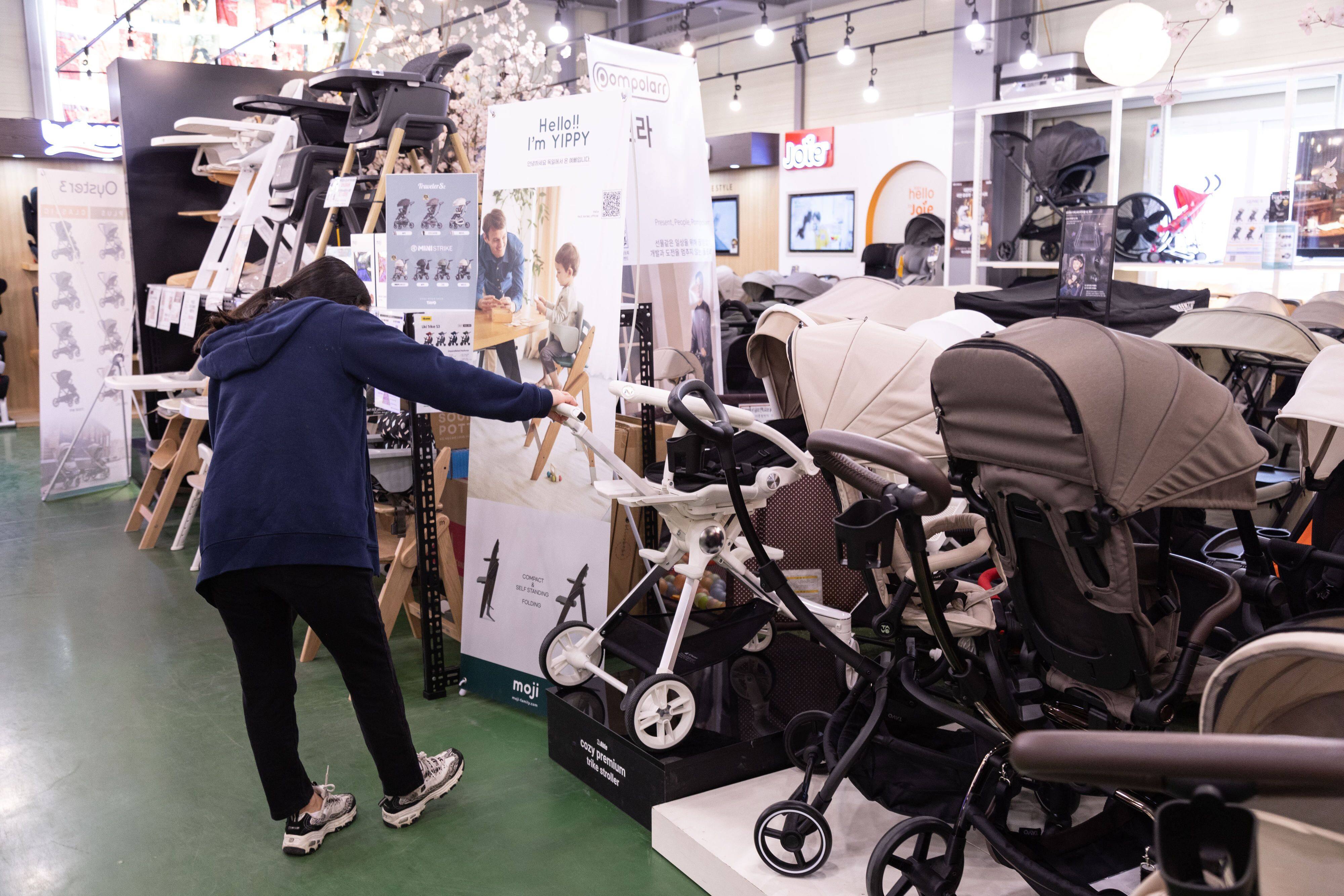 A customer looks at prams at a baby supplies store in Siheung, South Korea. Photo: Bloomberg