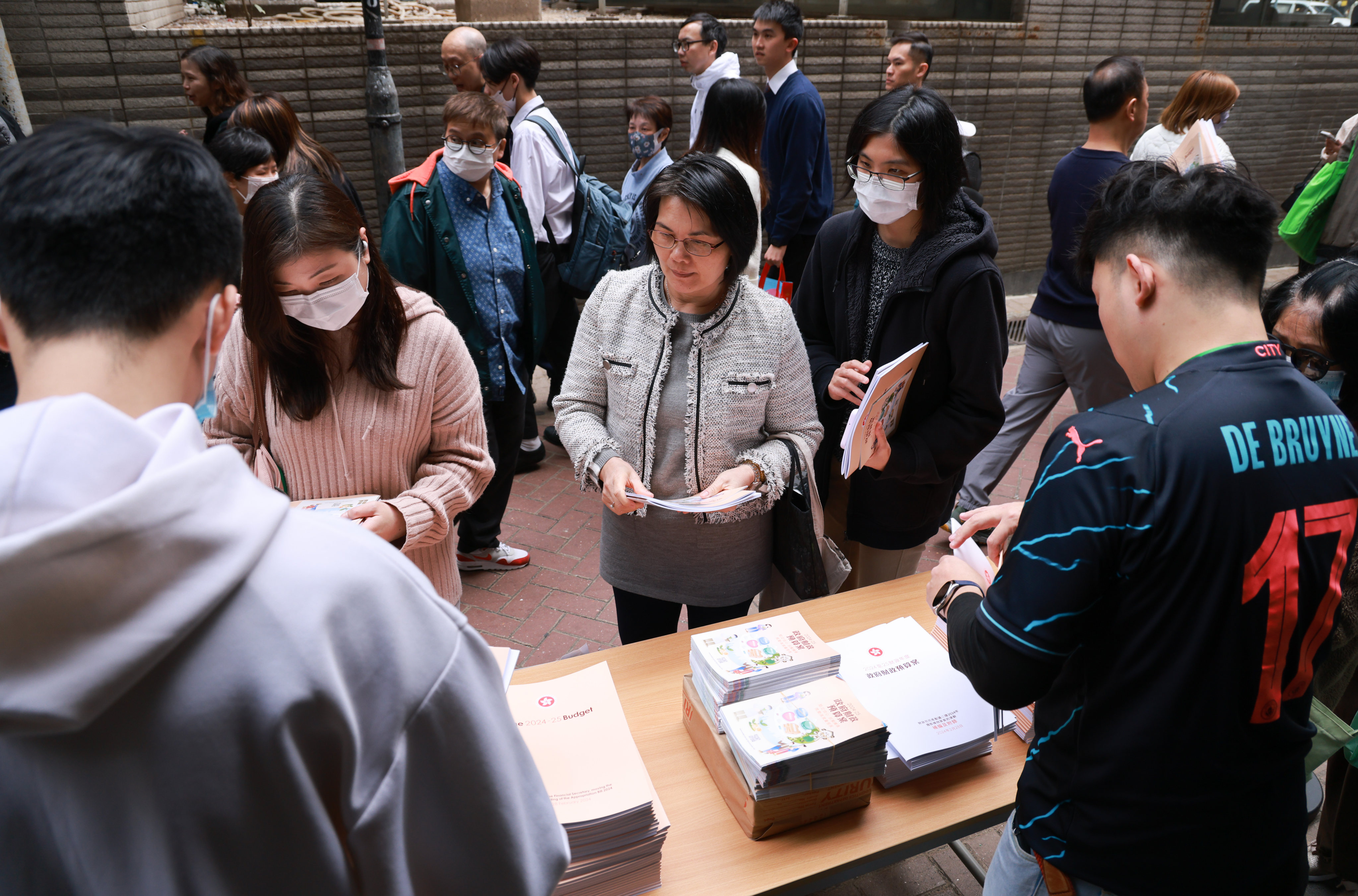 Residents of Hong Kong’s Wan Chai district browse copies of the budget speech and other informational leaflets on February 28. Photo: May Tse