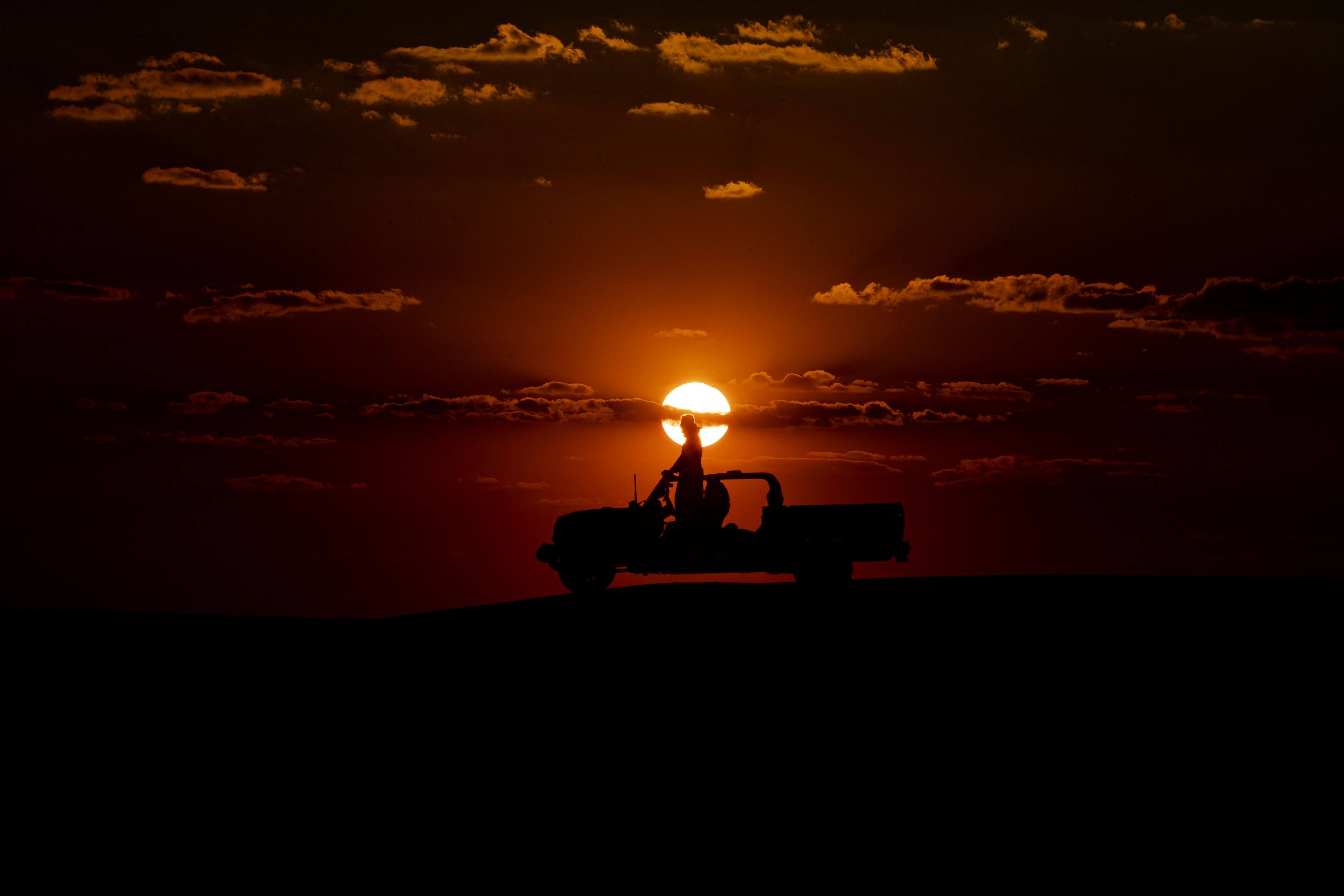 An Iraqi camper watches the sunset from his geep in the Samawa desert south of Baghdad on February 2, 2024. Far from the hustle and bustle of major cities, young Iraqis are increasingly taking advantage of a renewed sense of safety to explore the country’s serene desert getaways. (Photo by Hussein FALEH / AFP)