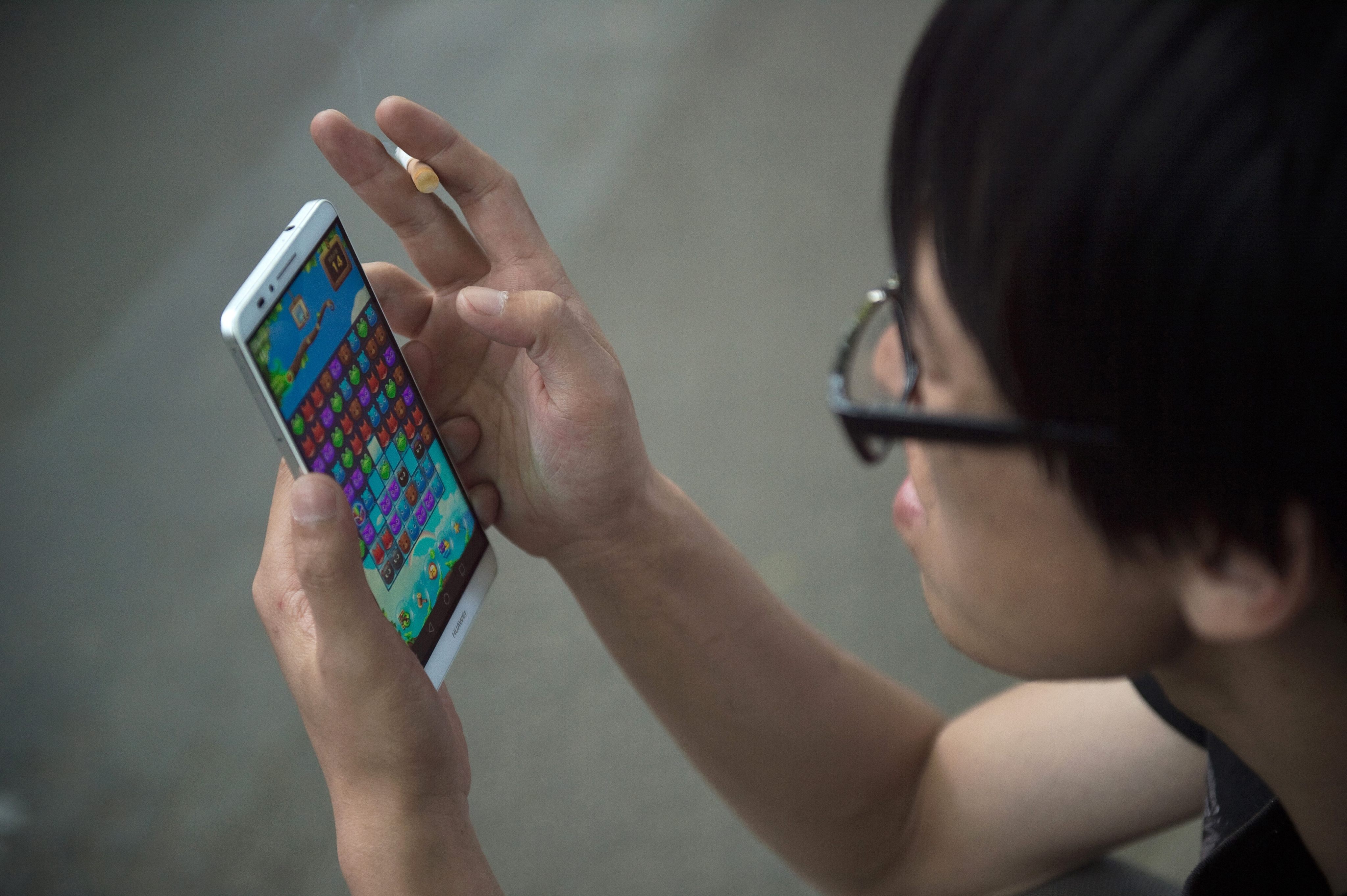A Chinese man uses his smartphone to play a game. The name of the “live game” involved in the case was not disclosed. Photo: AFP