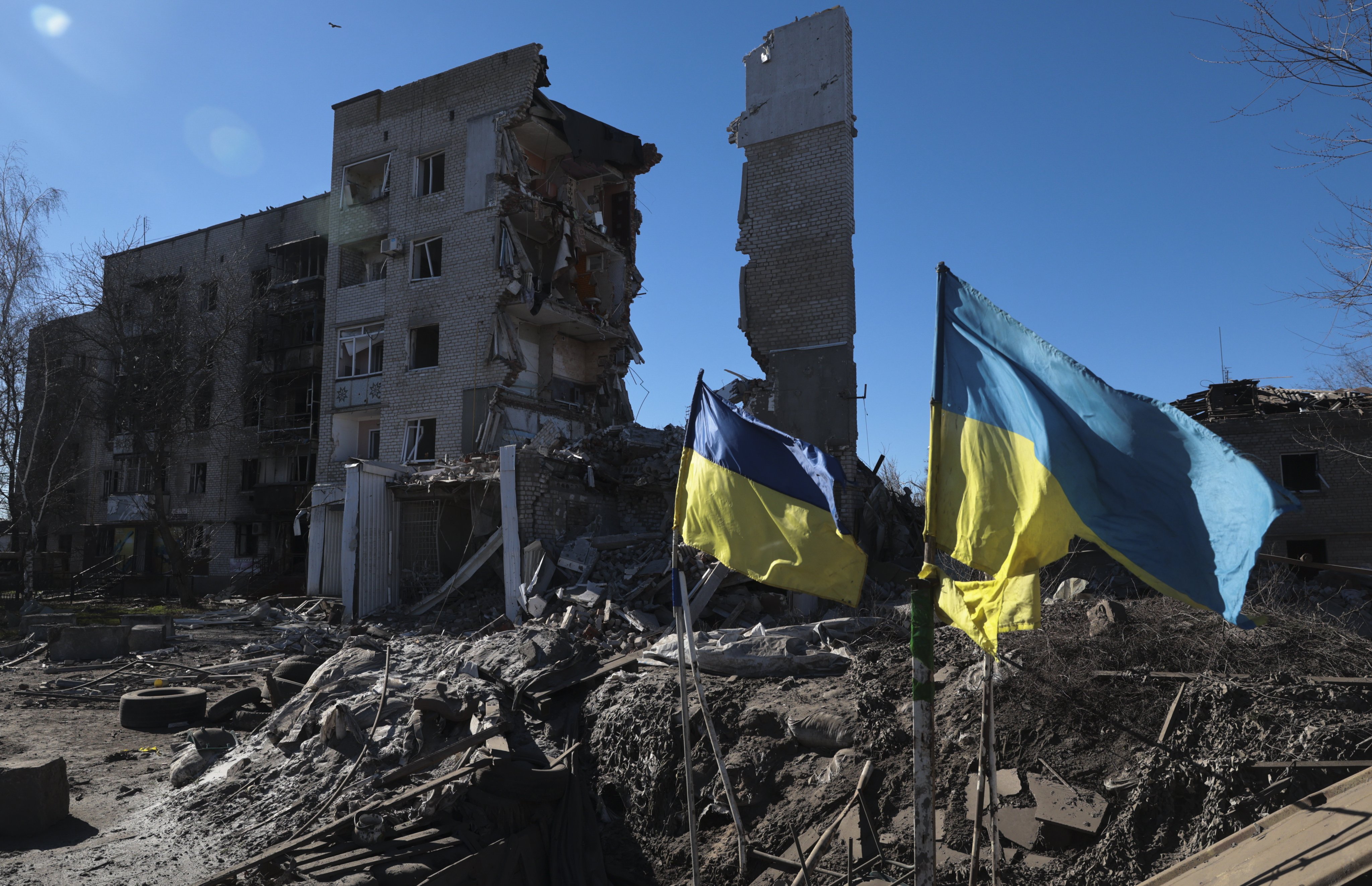 Ukrainian flags wave in front of damaged residential buildings in Orikhiv, near the frontline in the Zaporizhzhia region. Photo: EPA-EFE