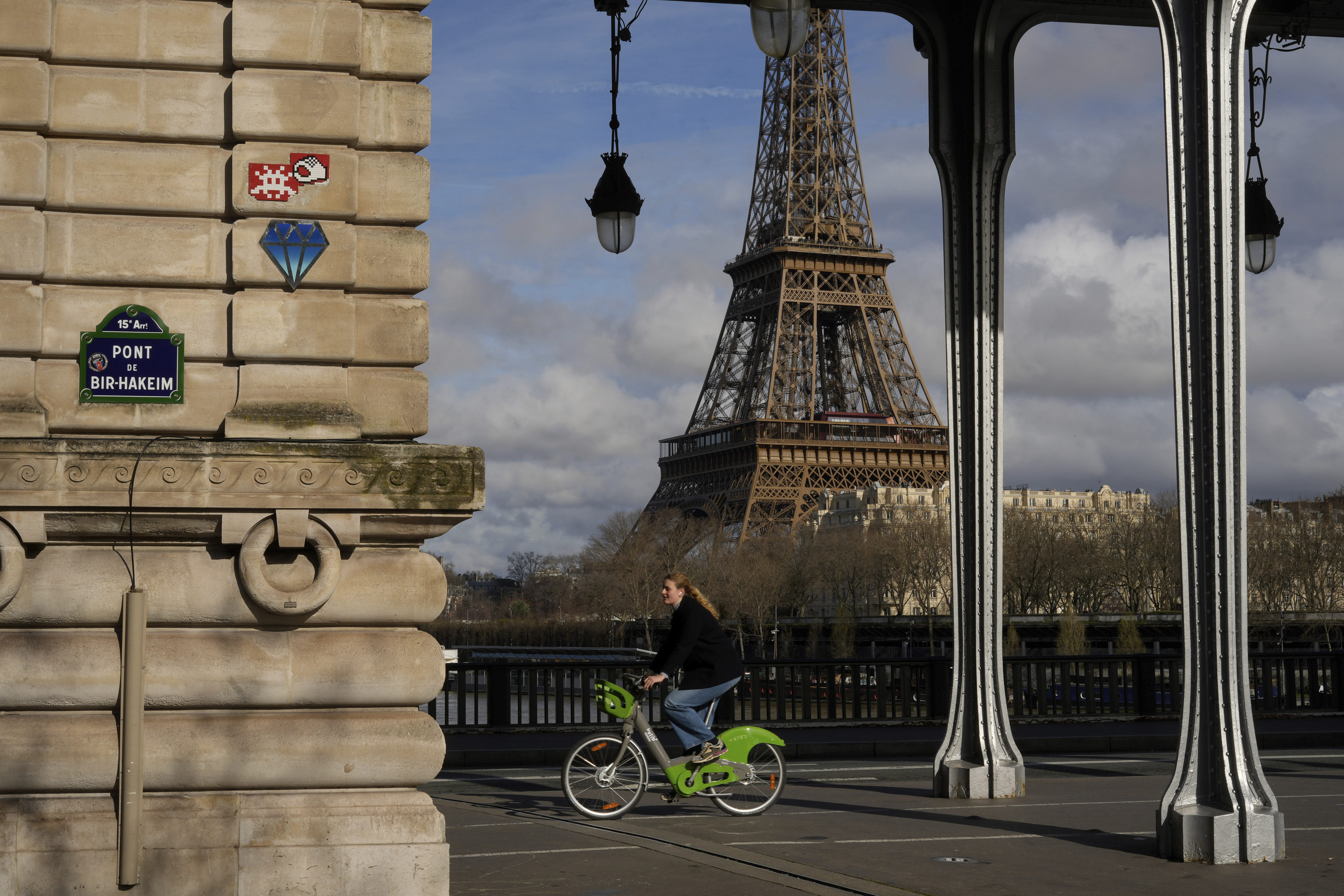 A mosaic by French artist Invader, in red top left, is seen on a street of Paris, near the Eiffel Tower, Friday, March 1, 2024. For the Paris Olympics, it could almost have been a new sport: Score points by scouring France’s capital for mosaics that a mystery artist who calls himself “Invader” has cemented to walls across the city, across the world and even had carried aloft to the International Space Station. (AP Photo/Thibault Camus)