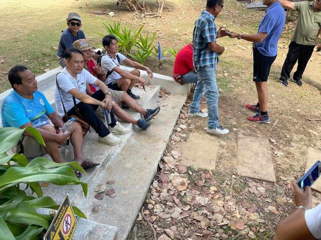 Phuket residents sit on the stairway that has been at the centre of an assault case involving a Swiss expat and a Thai doctor. Photo: Facebook