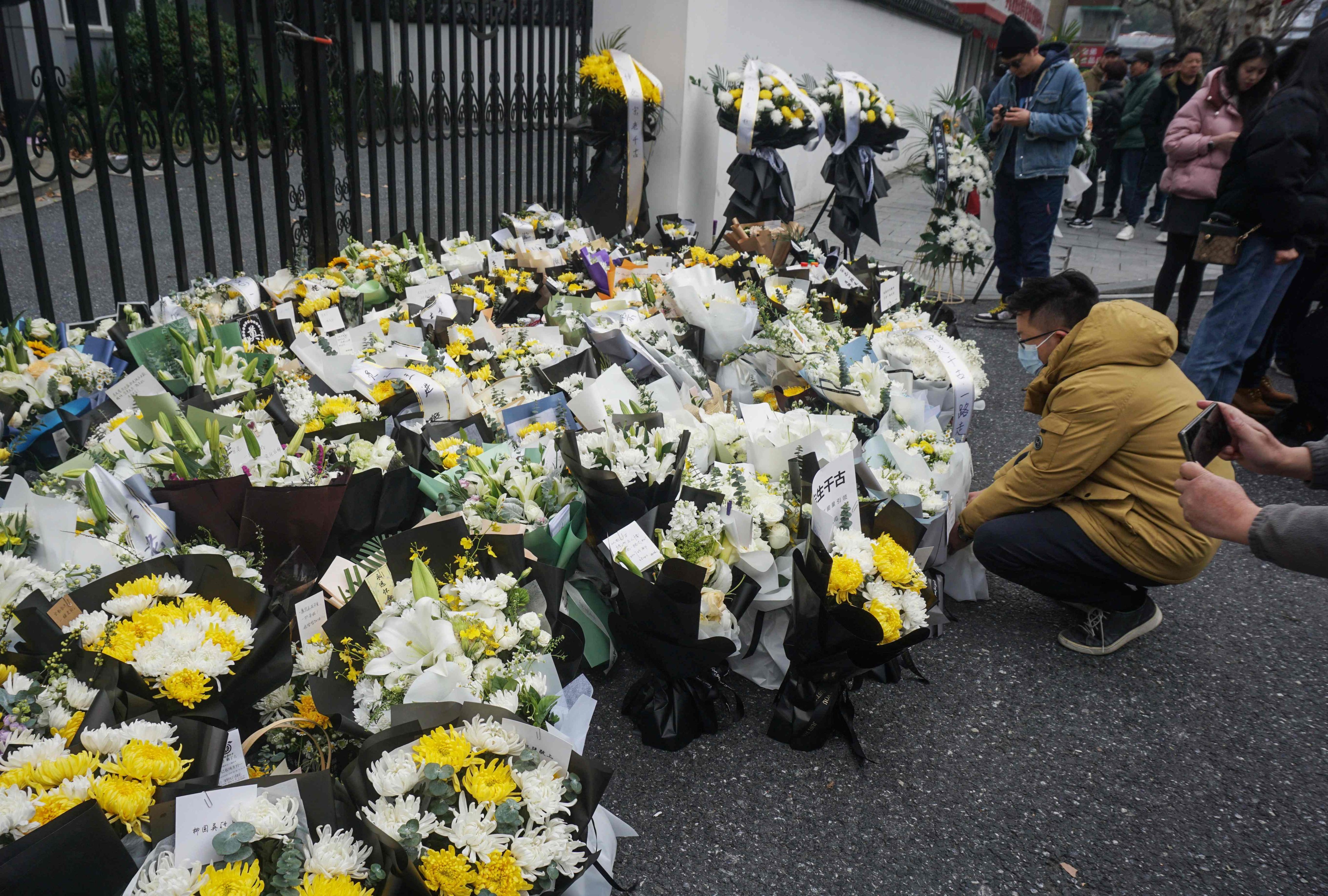People pay their respects and place bouquets outside the headquarters of Wahaha following the death of its founder Zong Qinghou, in Hangzhou in eastern China’s Zhejiang province on February 26. Photo: AFP