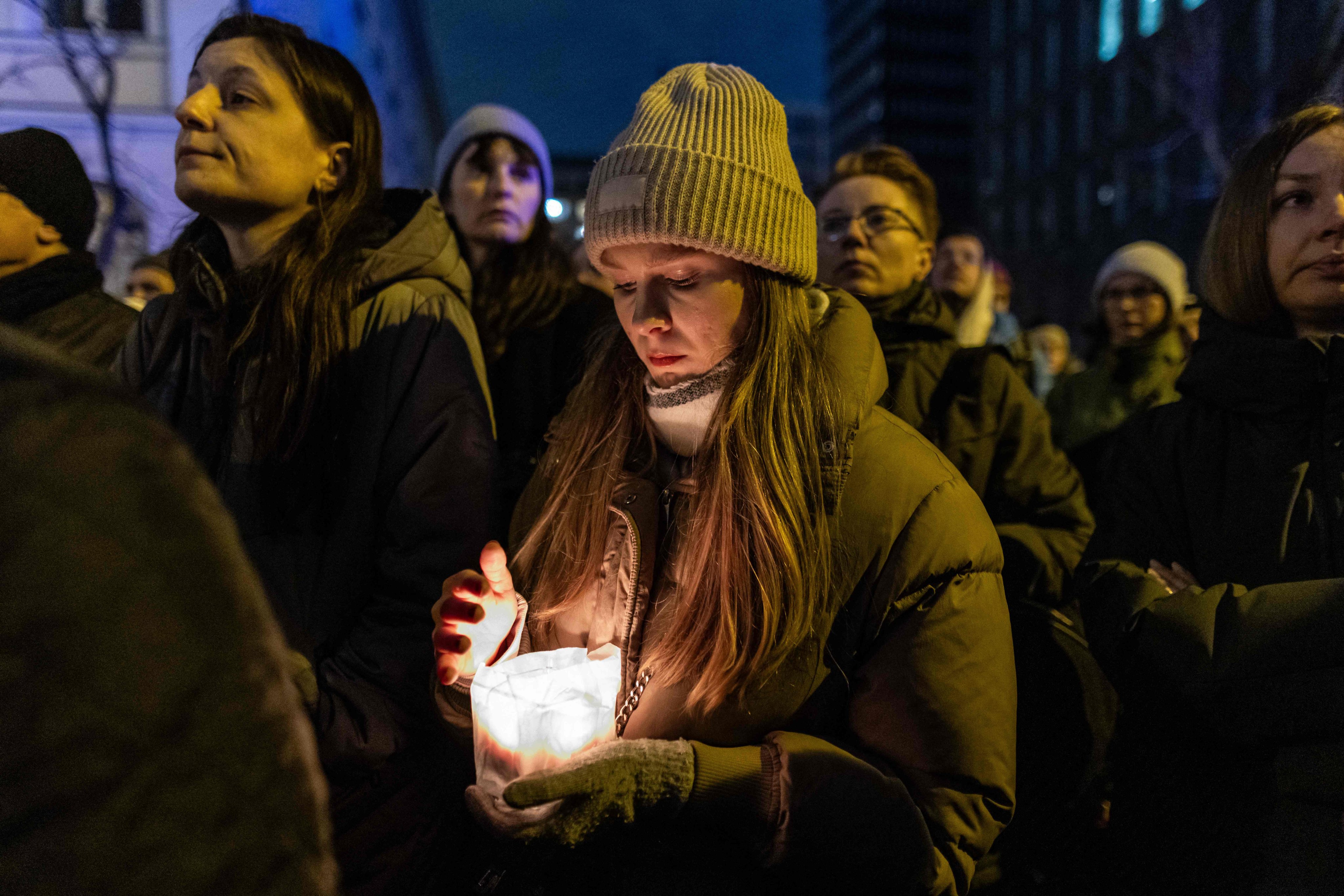 A woman holds a candle as she attends a vigil on Wednesday for Liza, a 25 year-old refugee from Belarus who died after being attacked, raped and severely beaten in downtown Warsaw. Photo: AFP