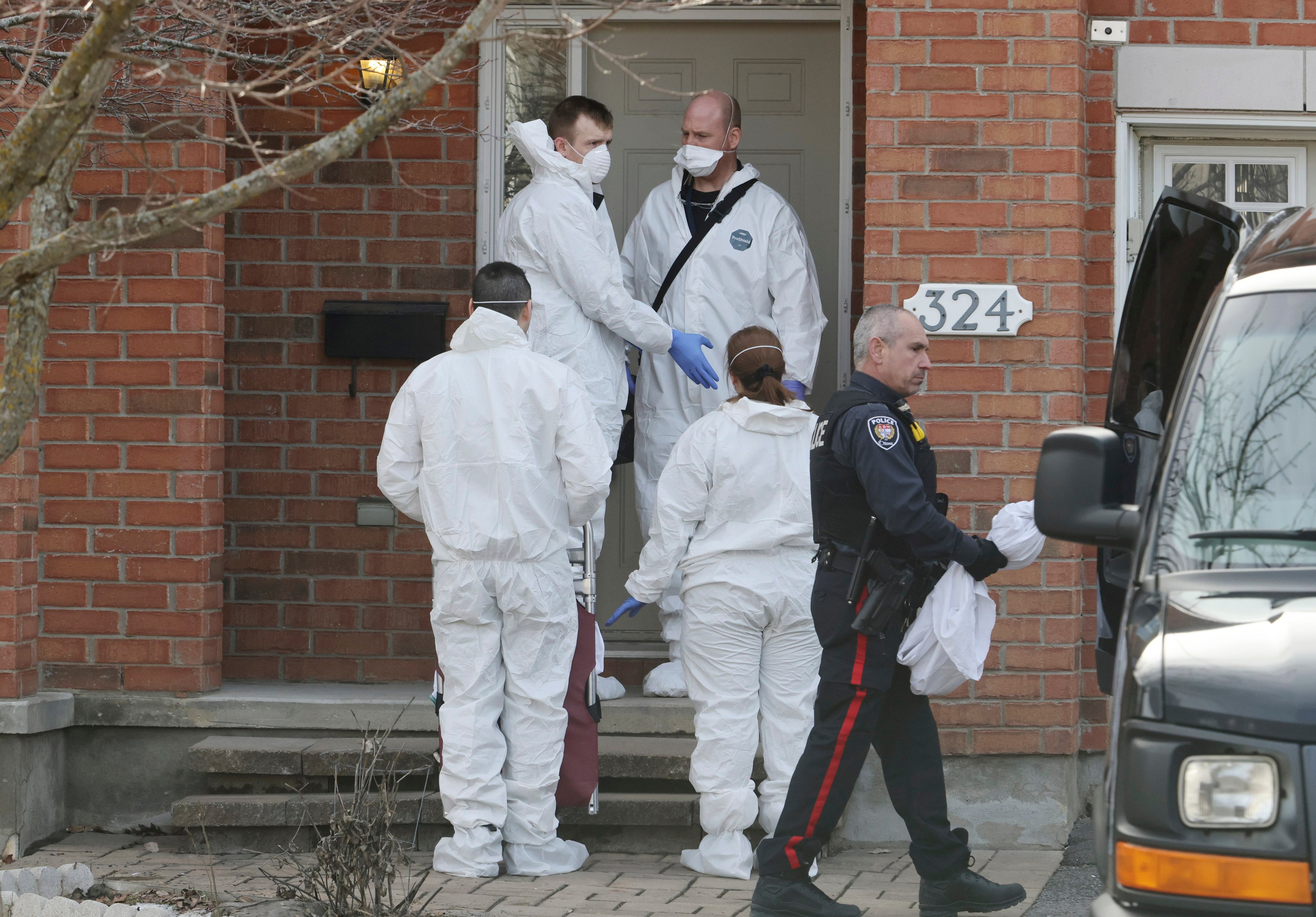 Members of the coroner’s office stand outside the scene of a homicide where six people were found dead in the Barrhaven suburb of Ottawa on Thursday. Photo: Canadian Press via AP