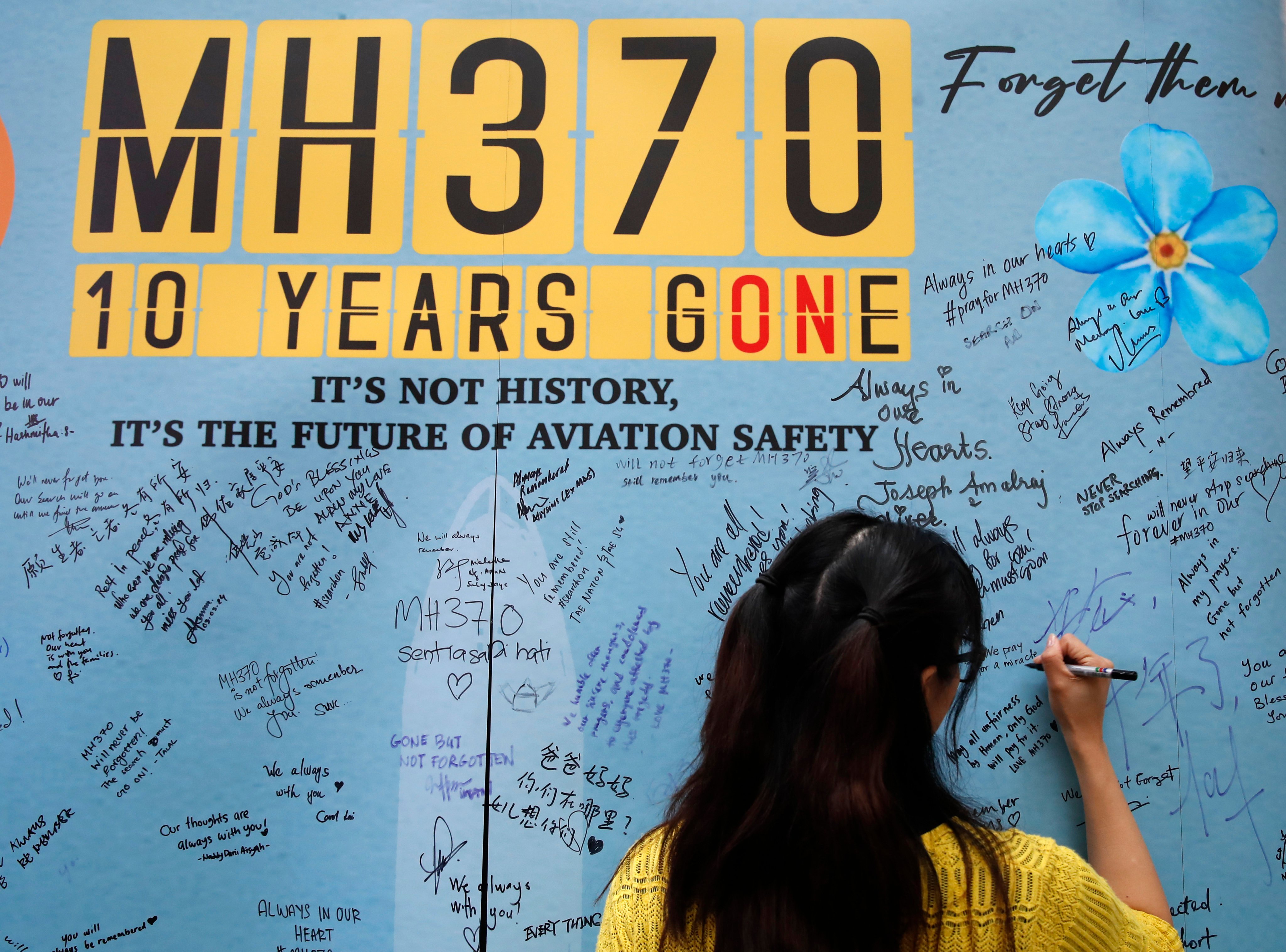 A woman writes on a message board during the 10th annual remembrance of the disapperance of Malaysia Airlines Flight 370 at a shopping mall in Subang Jaya, near Kuala Lumpur. Photo: AP