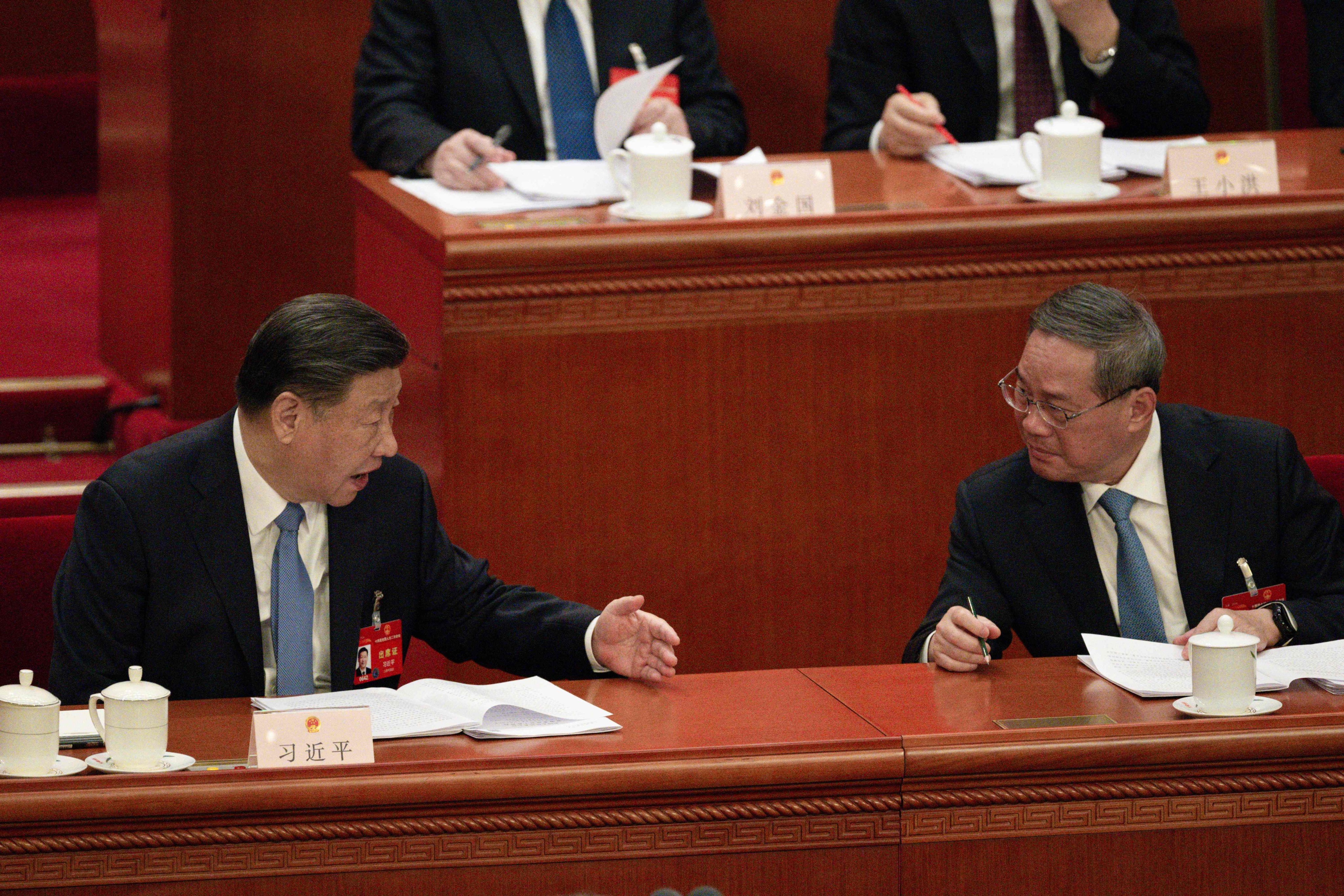 Chinese President Xi Jinping (left) speaks with Premier Li Qiang during the annual meeting of China’s top legislature in Beijing on Friday. Photo: AFP