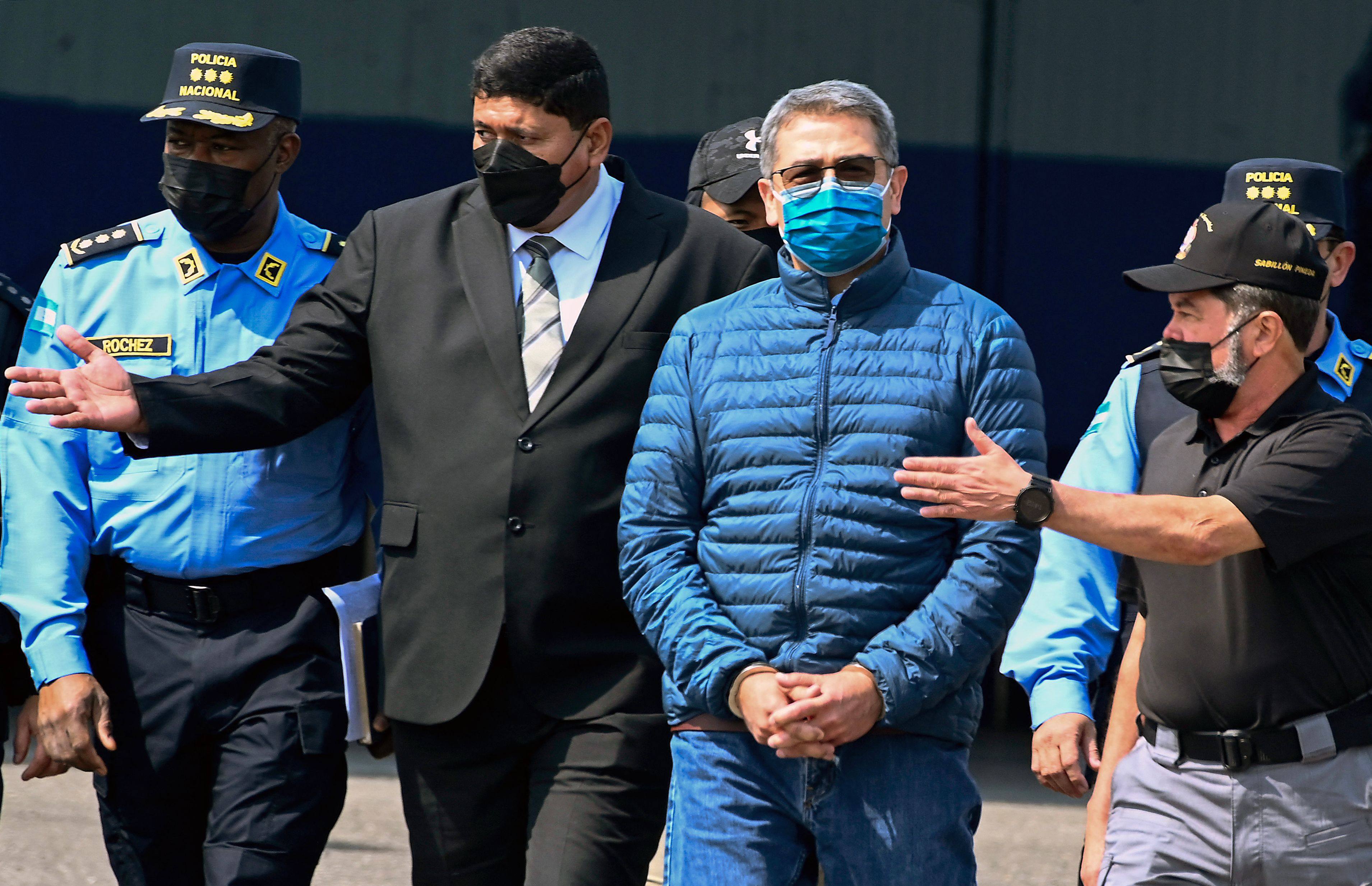 Former Honduras president Juan Orlando Hernandez (second from right) is escorted towards a plane for his extradition to the US at an air force base in Tegucigalpa in April 2022. Photo: AFP