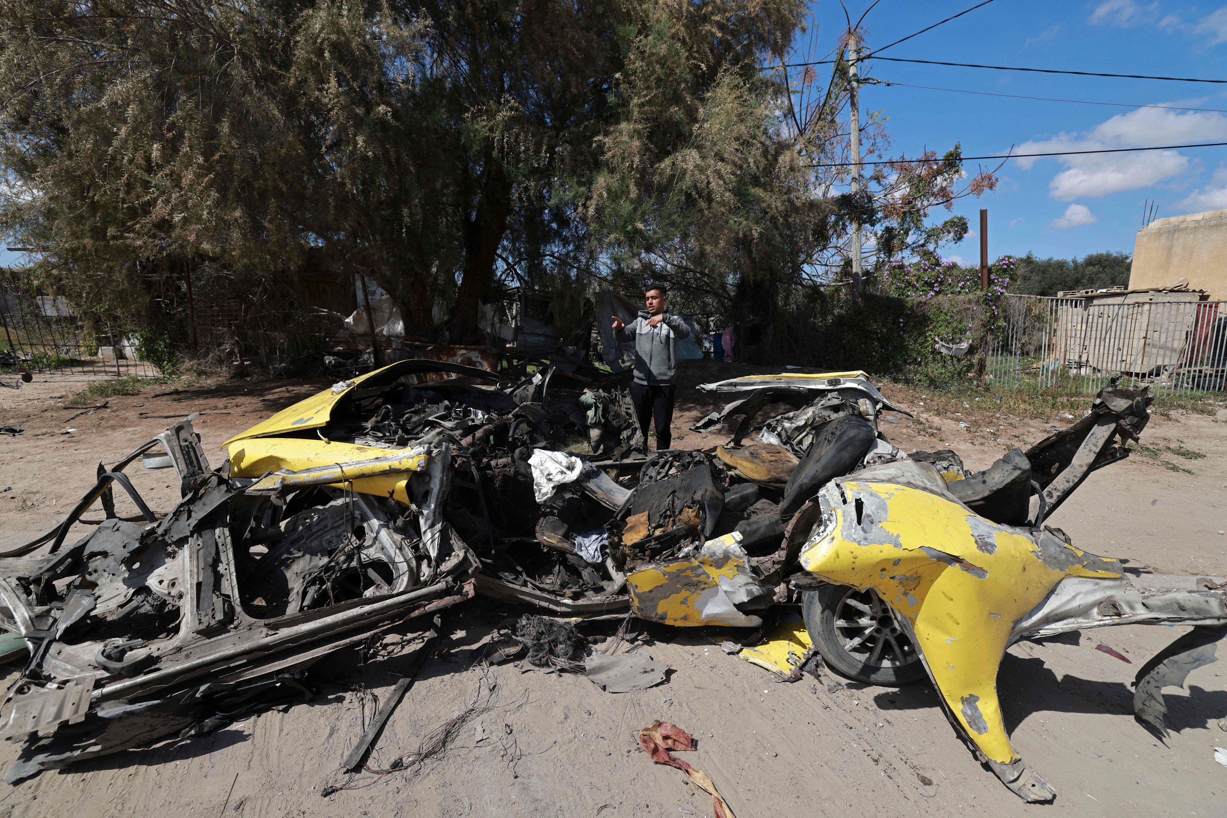 A Palestinian man inspects a car destroyed by Israeli bombardment in Gaza. Photo: AFP