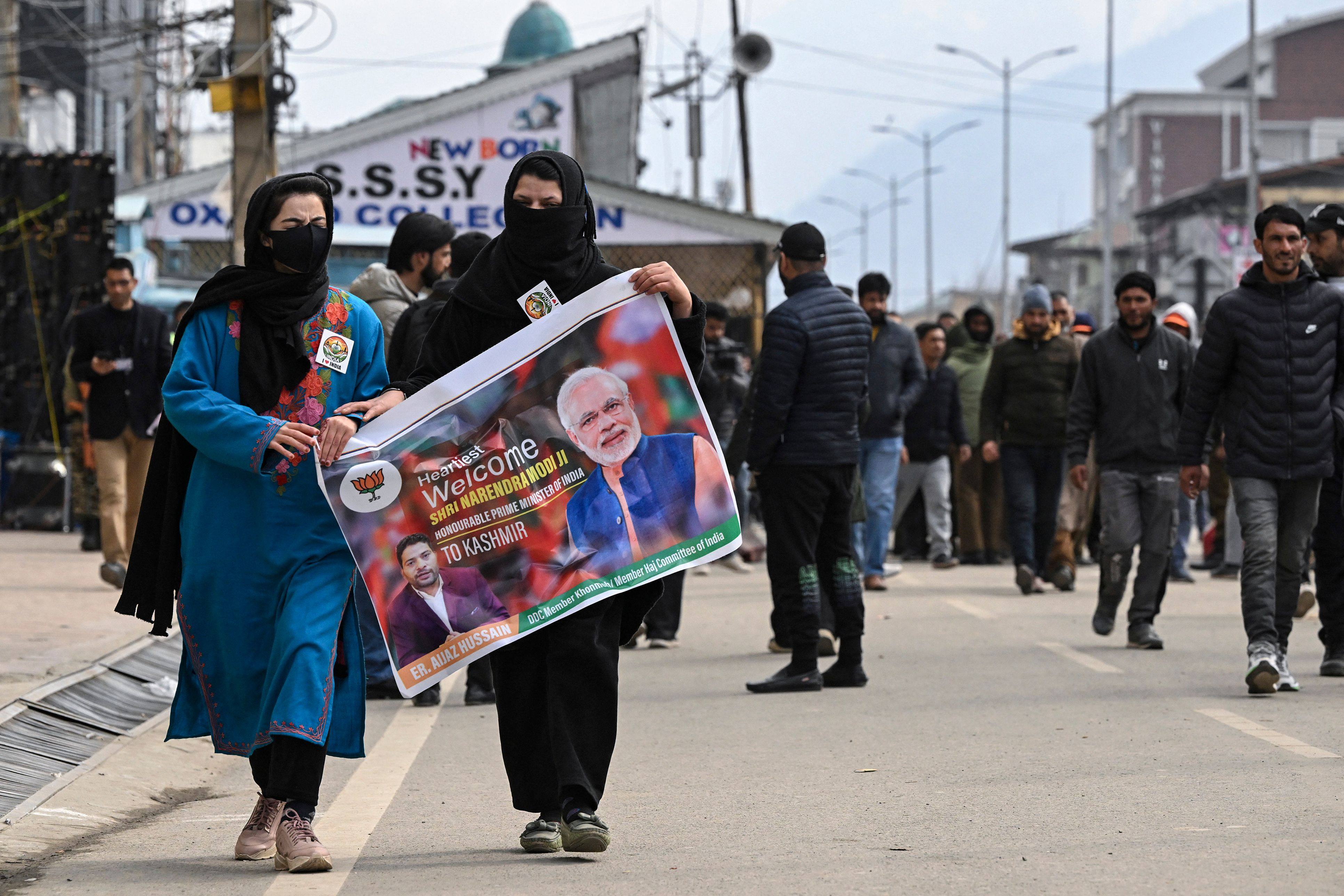 Supporters of Bhartiya Janta Party carry a poster ahead of a public rally by India’s Prime Minister Narendra Modi in Srinagar. Photo: AFP