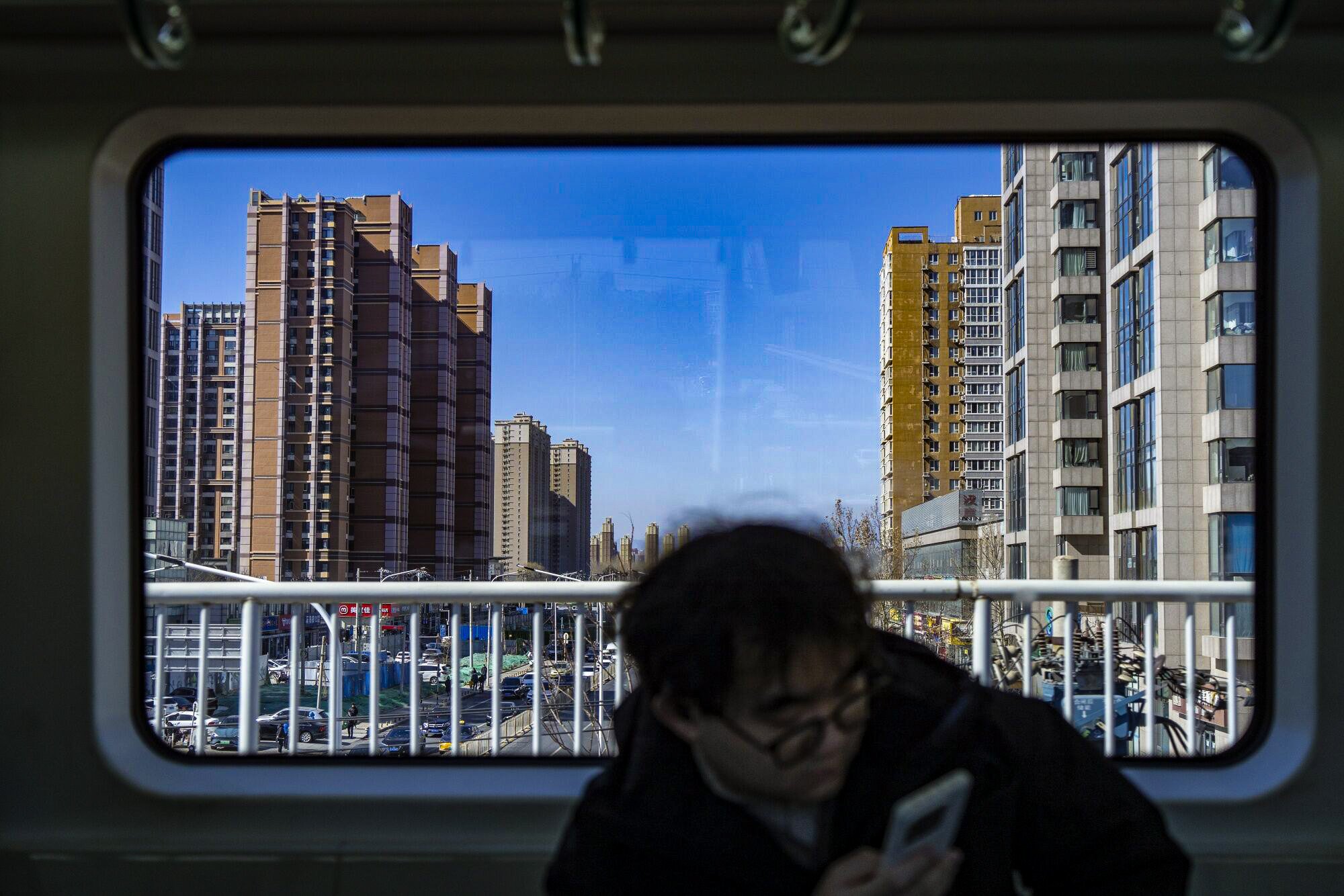 A commuter train passes residential buildings in Beijing on March 3, 2024. Photo: Bloomberg