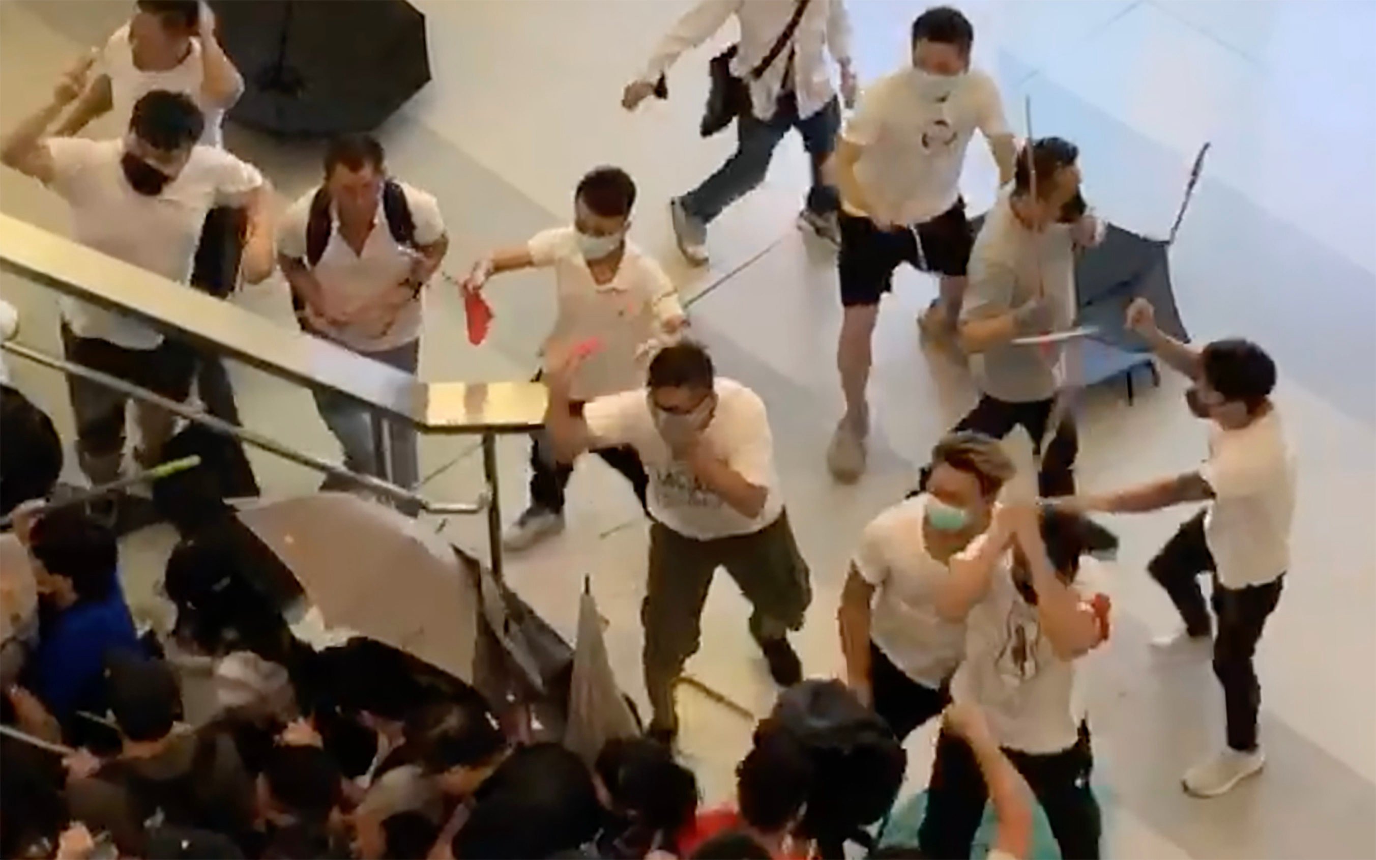 A screengrab from a video showing a number of people in white with wooden sticks chasing and assaulting people at Yuen Long Station in 2019. Photo: Handout