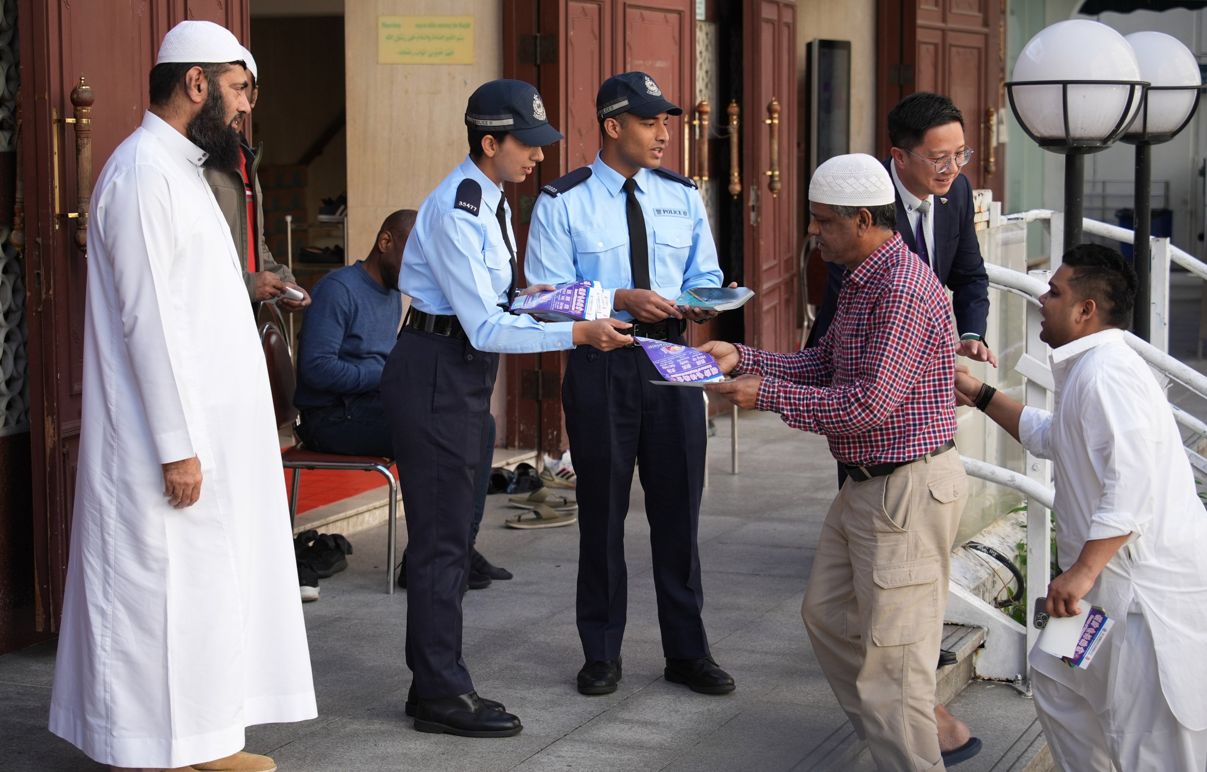 Constables Adnan Mohammad (third left) and Salma Bibi (second left) distribute anti-scam leaflets in Kowloon. They are among the more than 150 officers from an ethnic minority background. Photo: Eugene Lee
