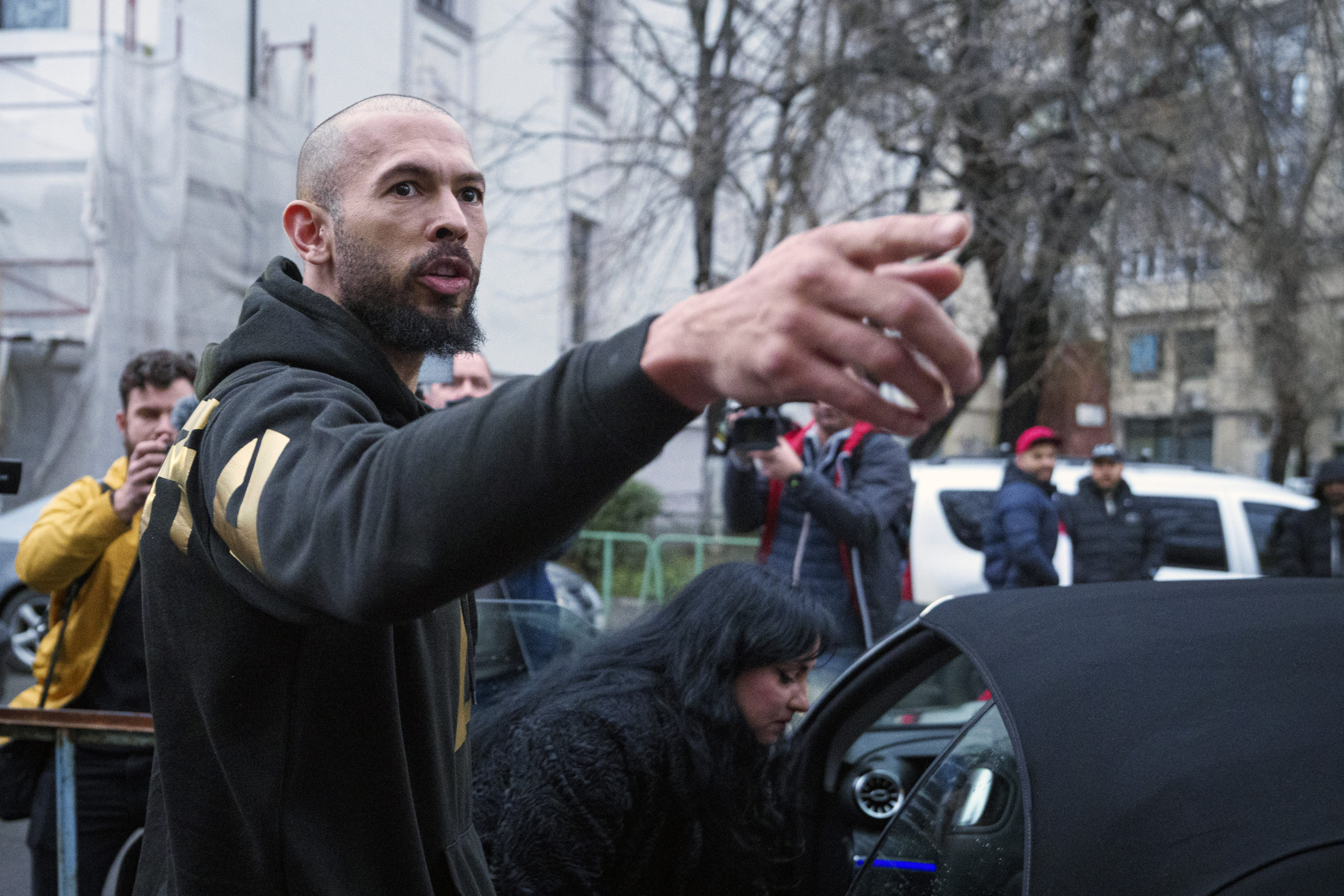 Andrew Tate gestures upon exiting a police detention facility in Bucharest, Romania, on Tuesday. Photo: AP