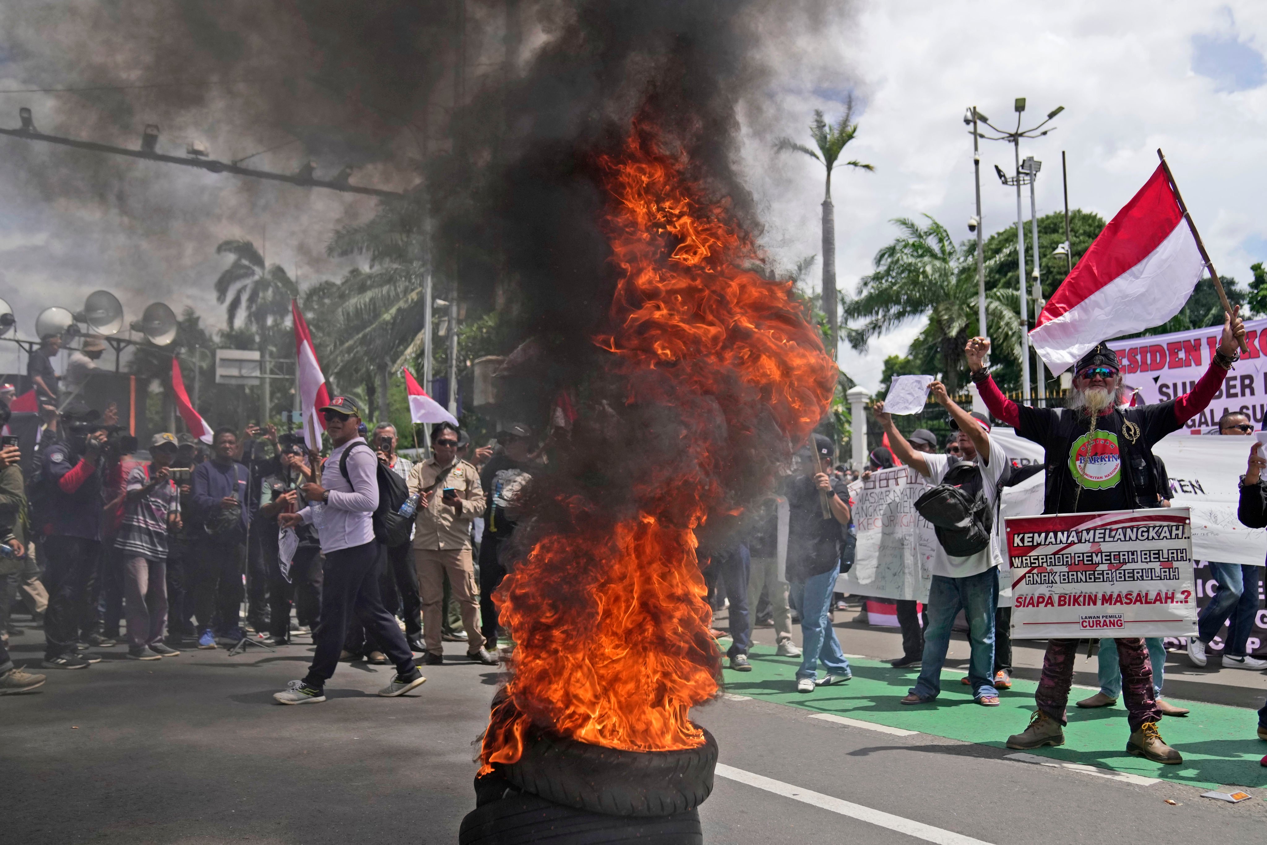 Protesters burn tyres during a rally on March 5 in Jakarta demanding the impeachment of Indonesian President Joko Widodo over allegations of election meddling. Photo: AP