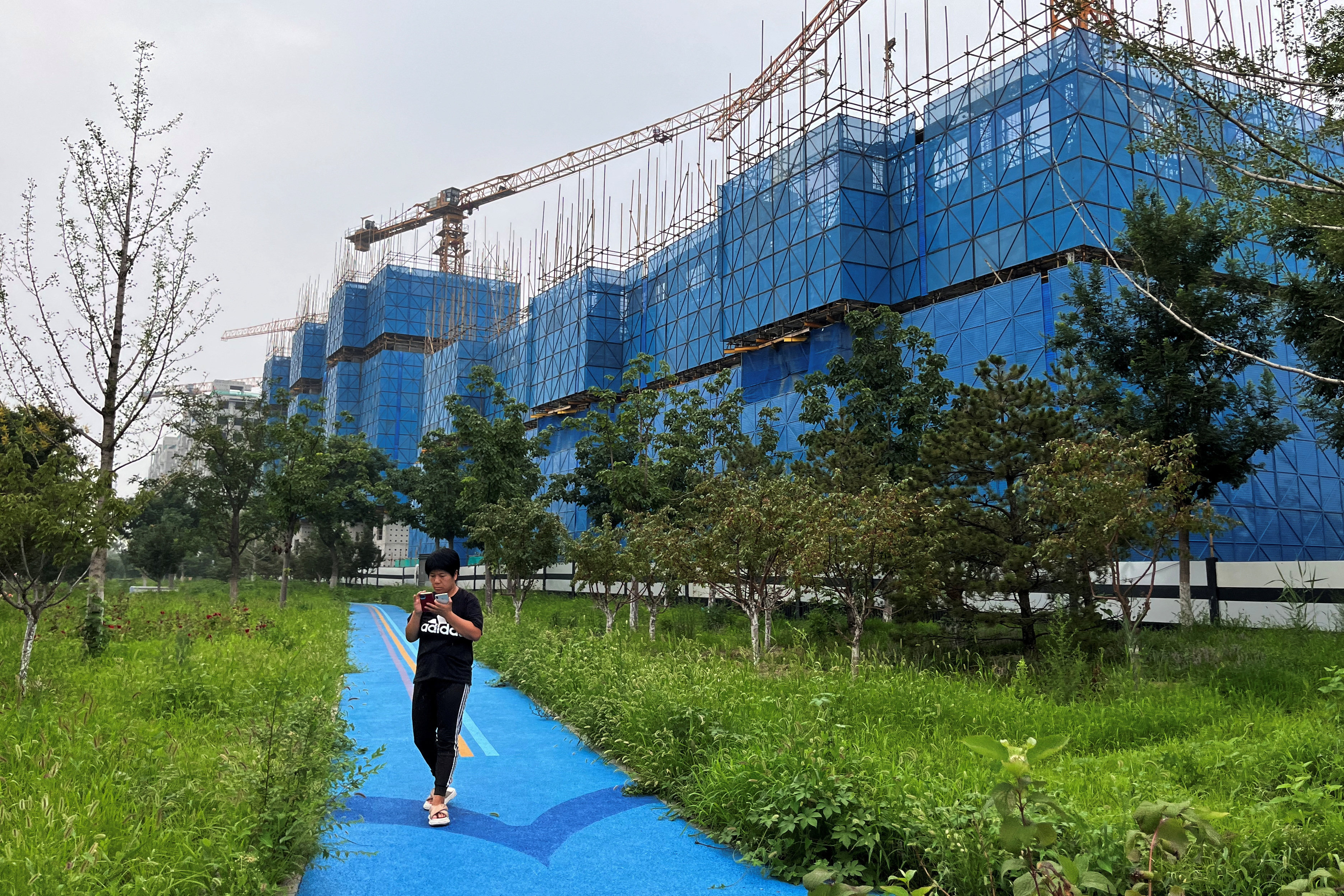 A person walks past a construction site of residential buildings by Country Garden, in Beijing on August 11, 2023. Photo: Reuters