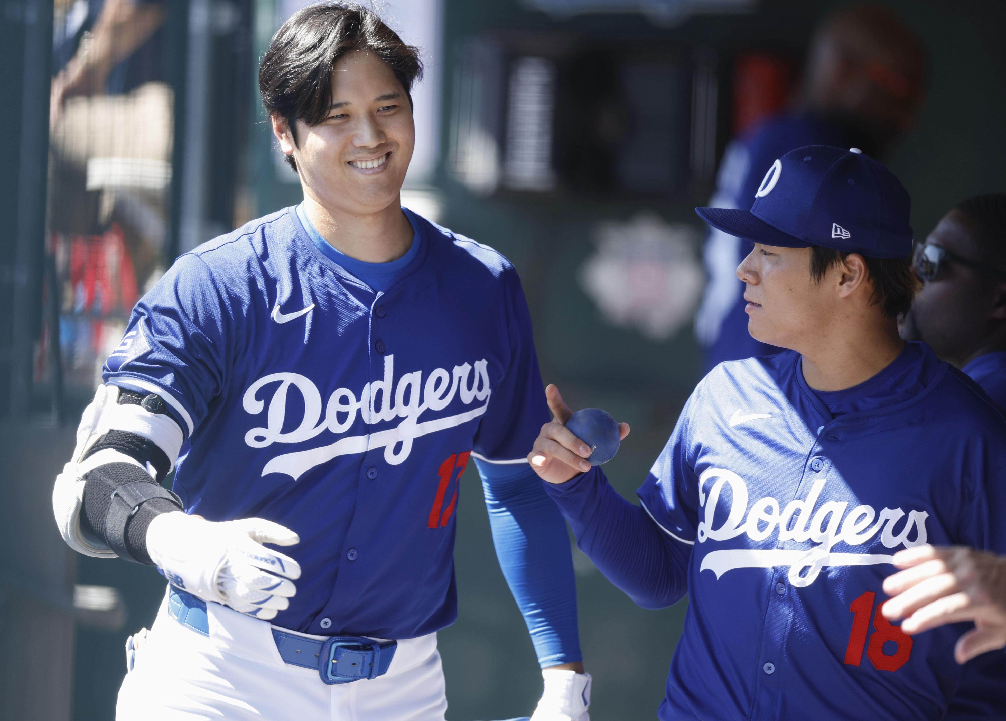 Shohei Ohtani (L) of the Los Angeles Dodgers chats with his teammate Yoshinobu Yamamoto in the dugout during a spring training baseball game against the Seattle Mariners in Glendale, Arizona, on March 13, 2024. (Kyodo)
==Kyodo