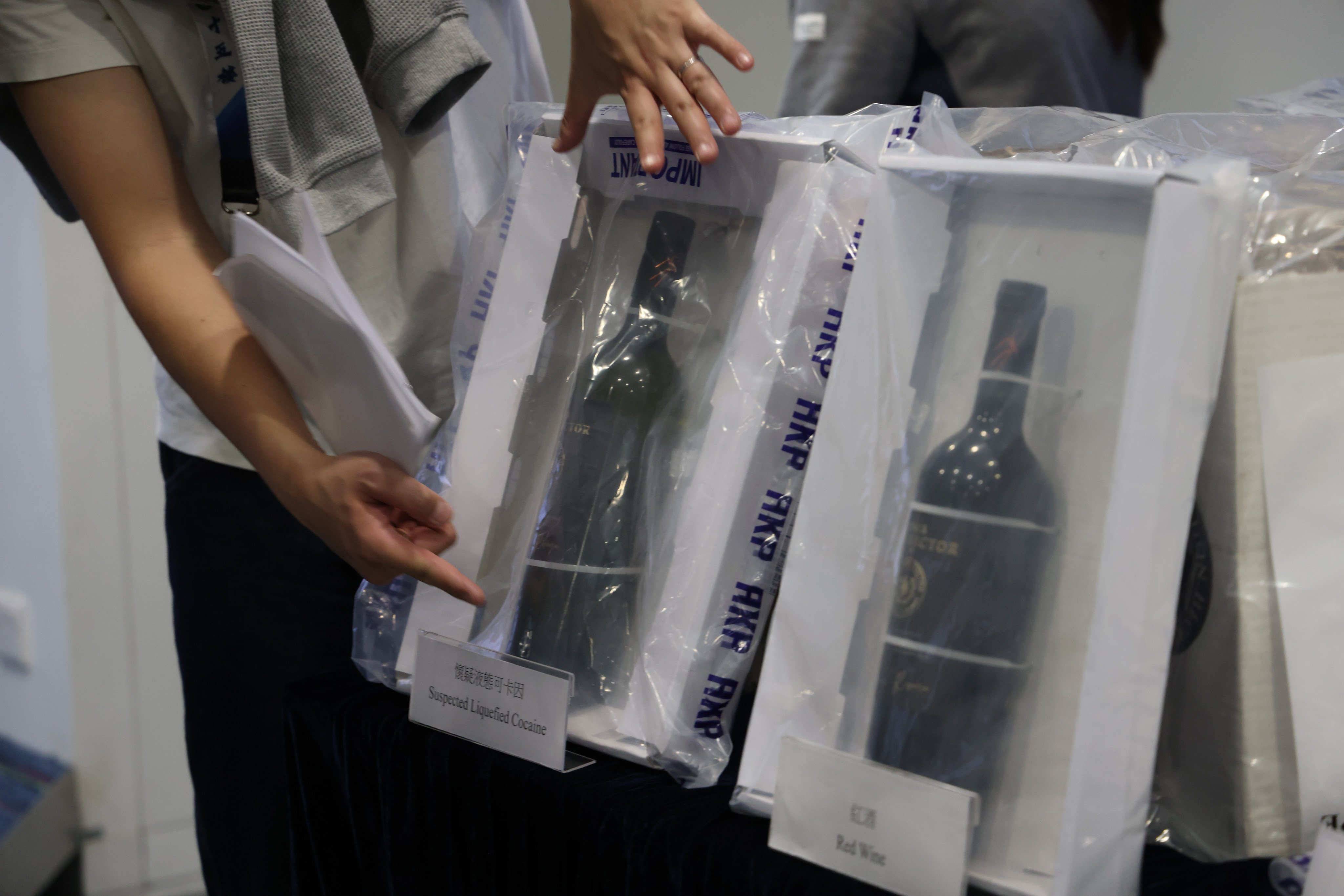 Officers show wine bottles allegedly to used conceal the liquid cocaine. Police also seized a 1kg slab of what appeared to be cocaine, 400 grams of suspected ketamine and 740 grams of cannabis buds. Photo: Jelly Tse