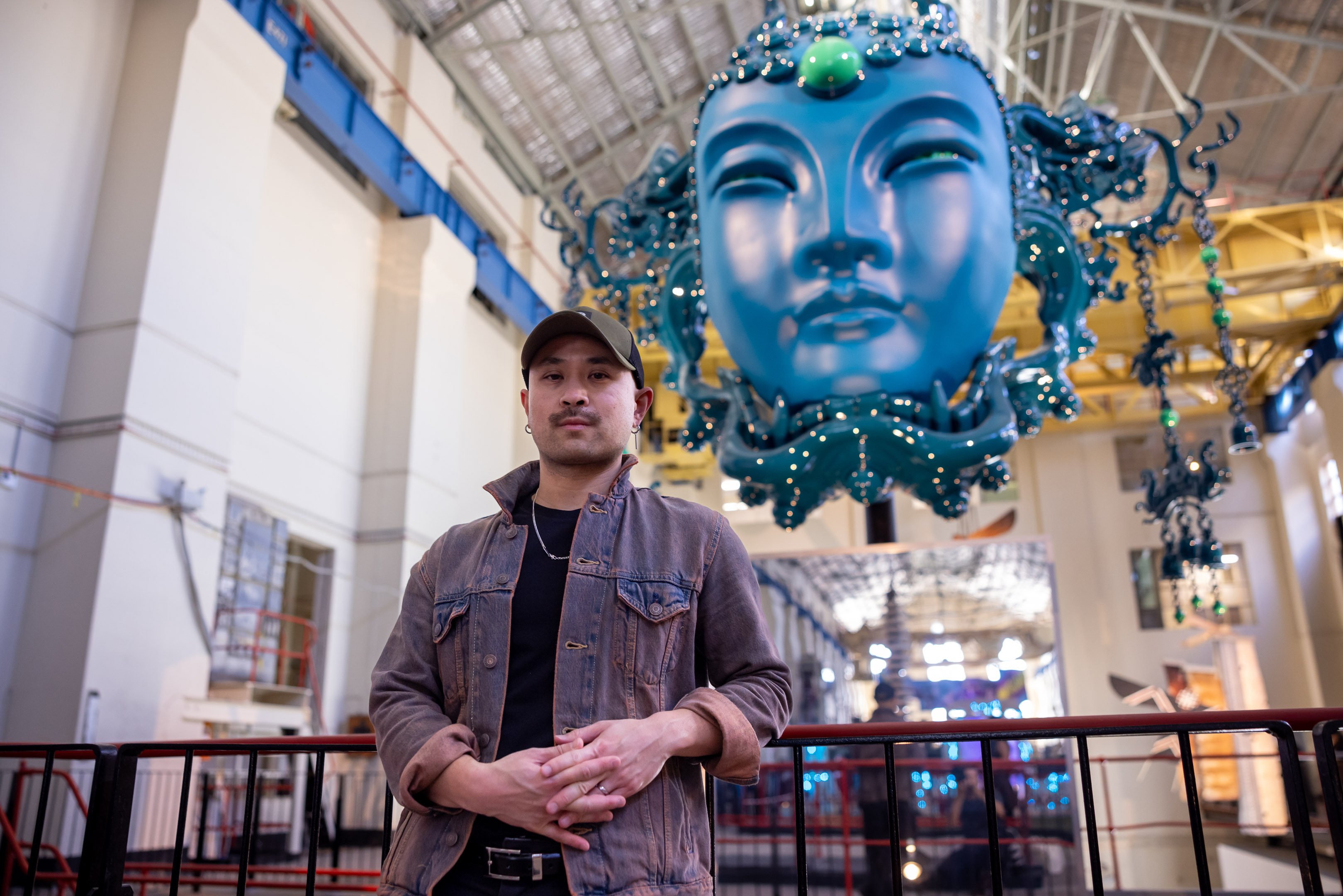 Andrew Thomas Huang with his work “The Beast of Jade Mountain: Queen Mother of the West” (2023–24) at the White Bay Power Station, Sydney, Australia. Photo: Daniel Boud