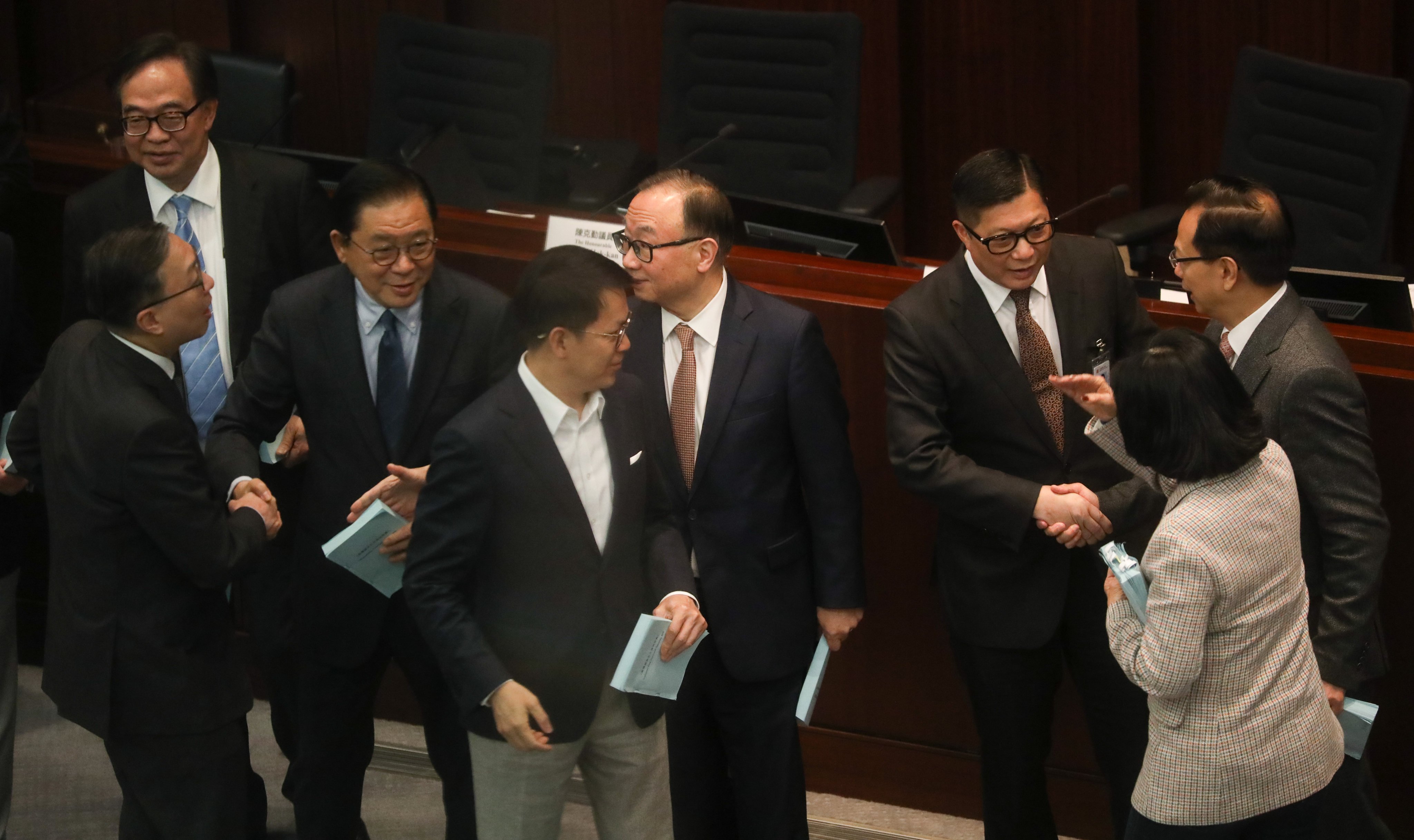 Lawmakers greet government ministers after the bills committee meeting on Thursday. Photo: Sun Yeung