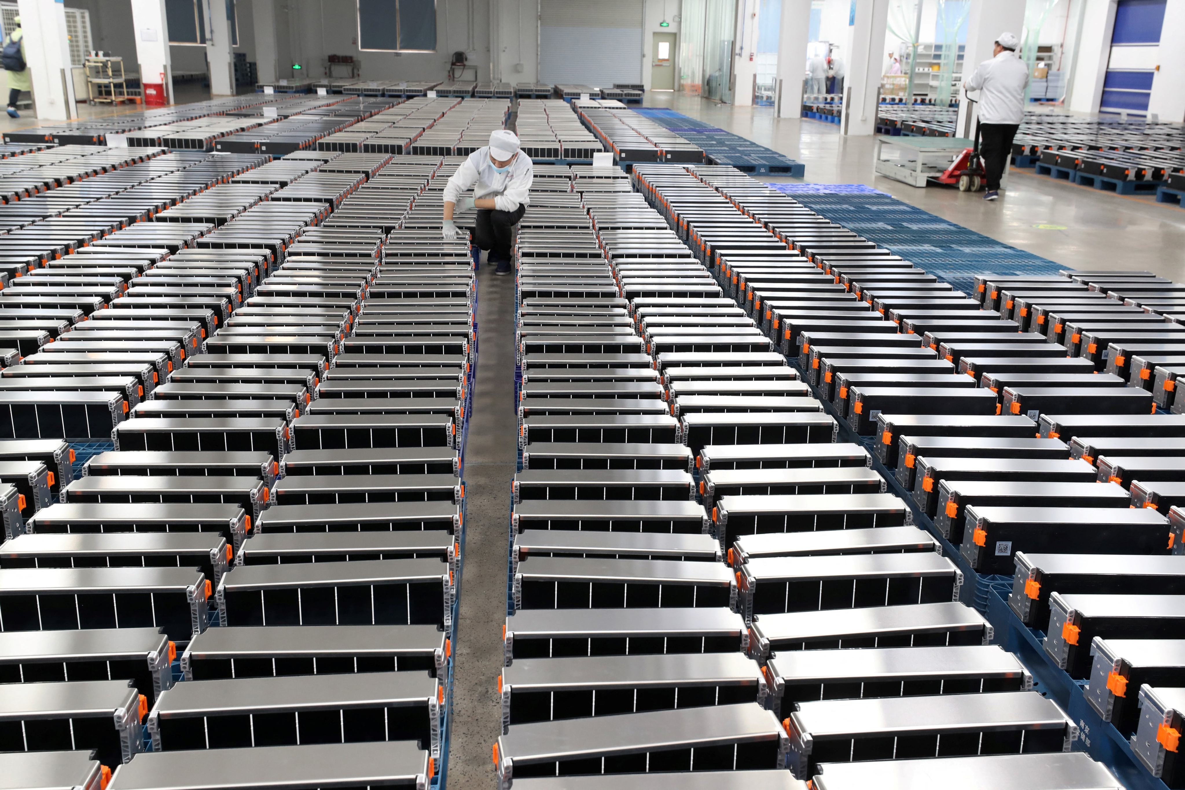 This photo taken on March 12, 2021 shows a worker with car batteries in a factory for Xinwangda Electric Vehicle Battery in Nanjing. Photo: AFP via Getty Images.
