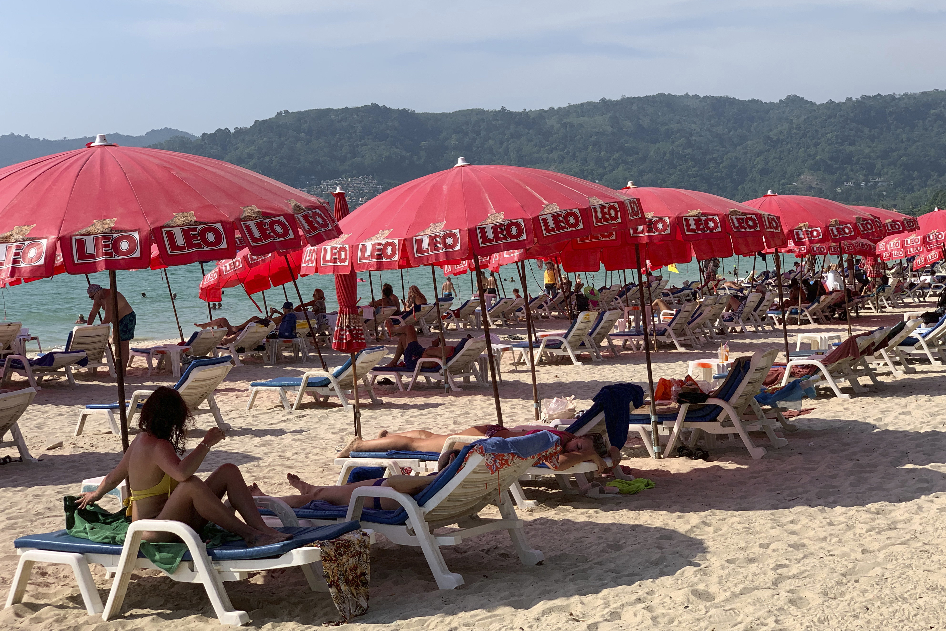Tourists lounge along Patong Beach in Phuket. Brothers Hamish Day and Oscar Mattson Day were charged with offences including robbery, causing physical harm to an on-duty officer, attempted bribery and driving a motorcycle without a licence. Photo: AP