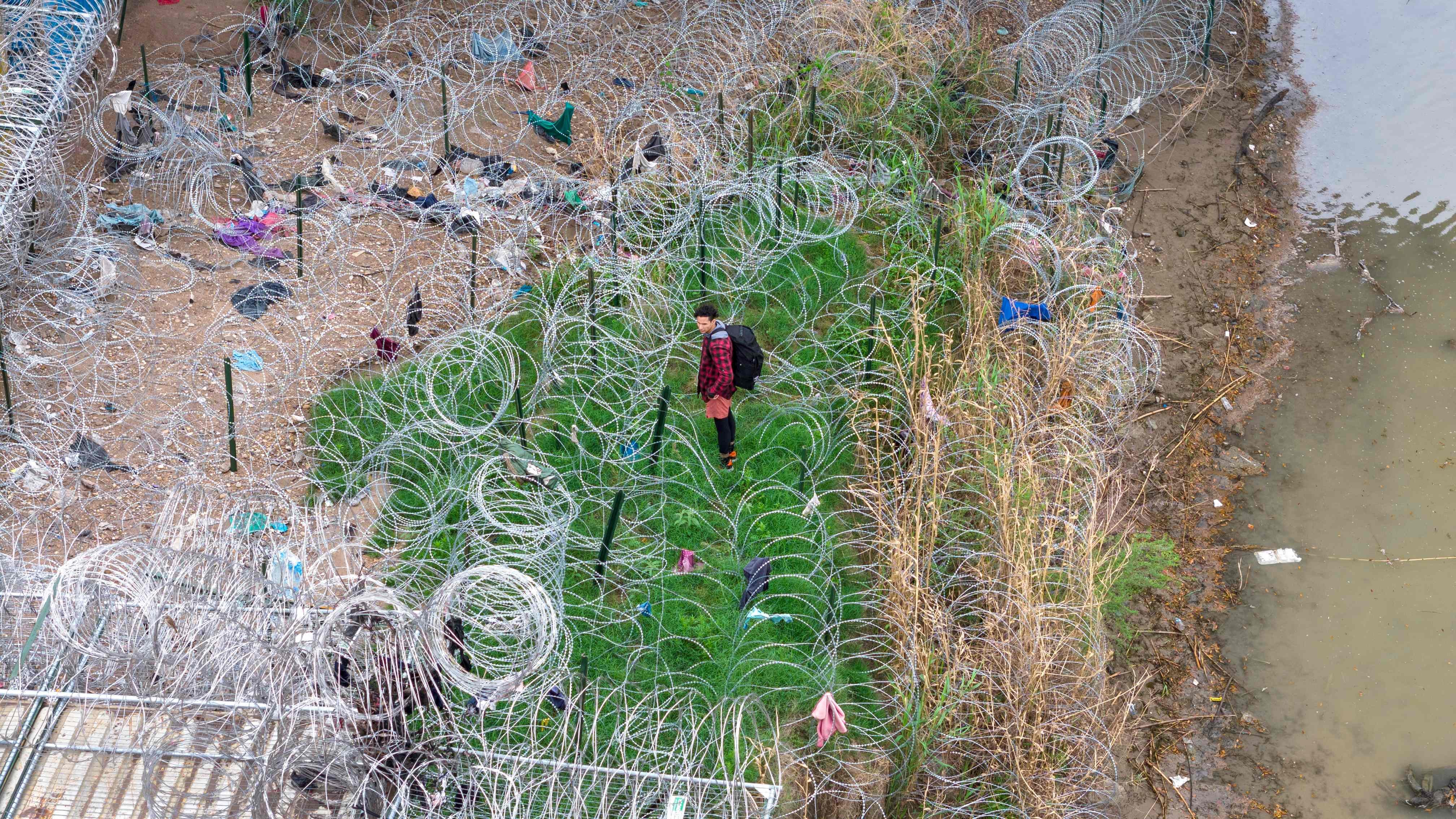 An immigrant faces coils of razor wire after crossing the Rio Grande from Mexico into the United States on March 17 in Eagle Pass, Texas. Texas National Guard troops have fortified Eagle Pass with vast amounts of razor wire as part of Governor Greg Abbott’s “Operation Lone Star” to deter migrants from crossing into Texas. Photo: AFP