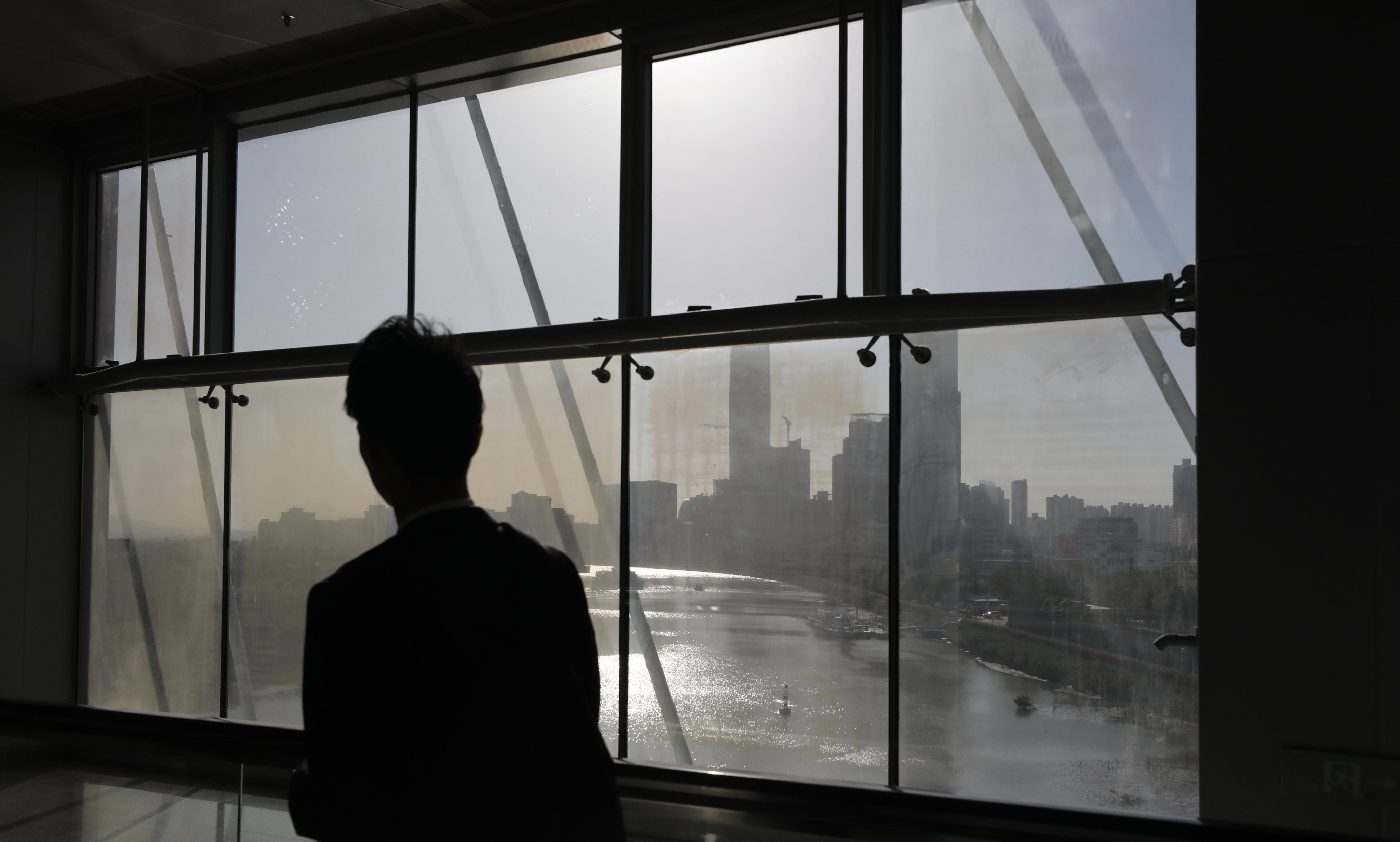 A man looks out from a window at the Futian-Lok Ma Chau Pedestrian Bridge. A University of Hong Kong official said the suicide prevention system would launch in two to three months. Photo: Xiaomei Chen